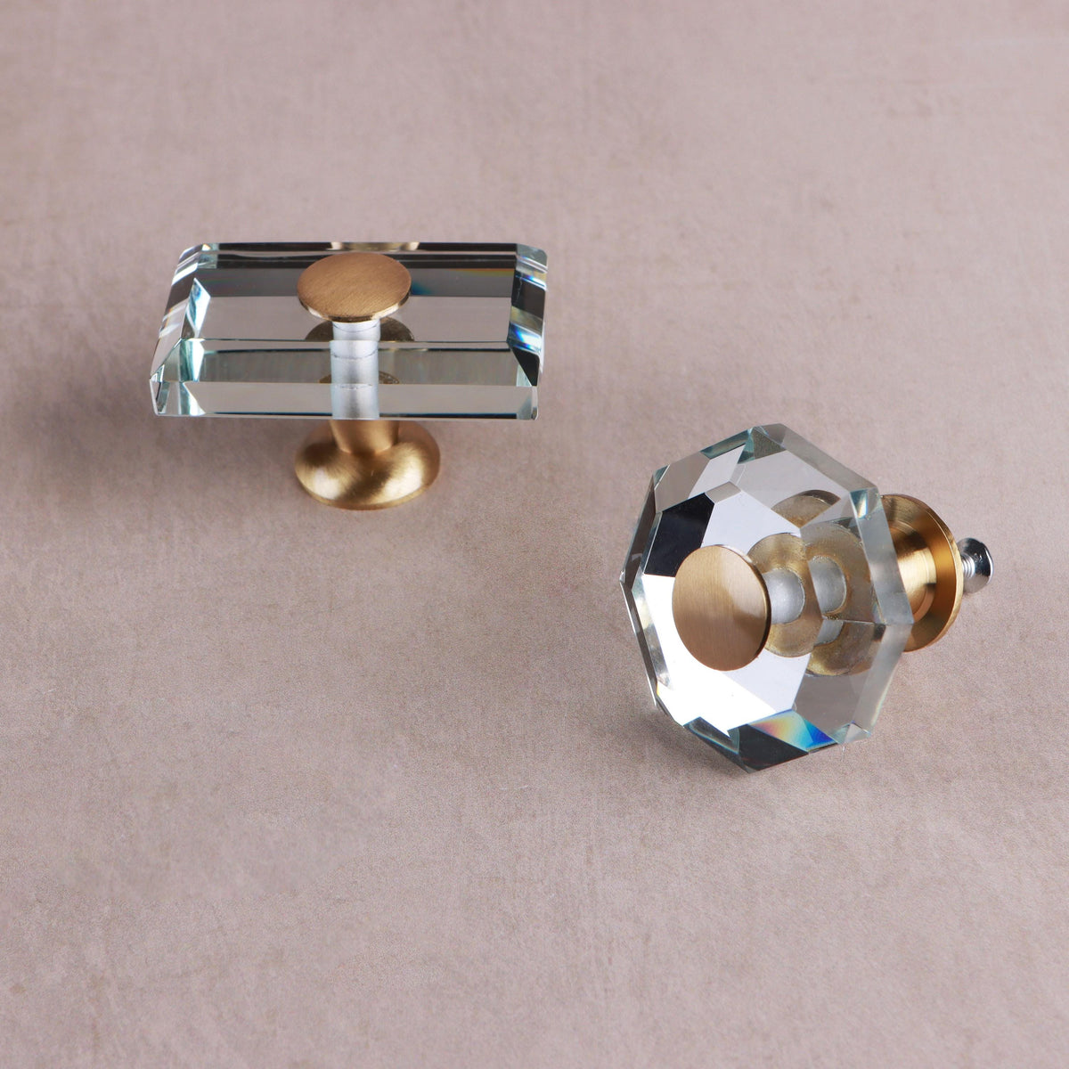 Octagon and rectangle clear crystal glass knobs from above, showing the bevelled edges and brass caps