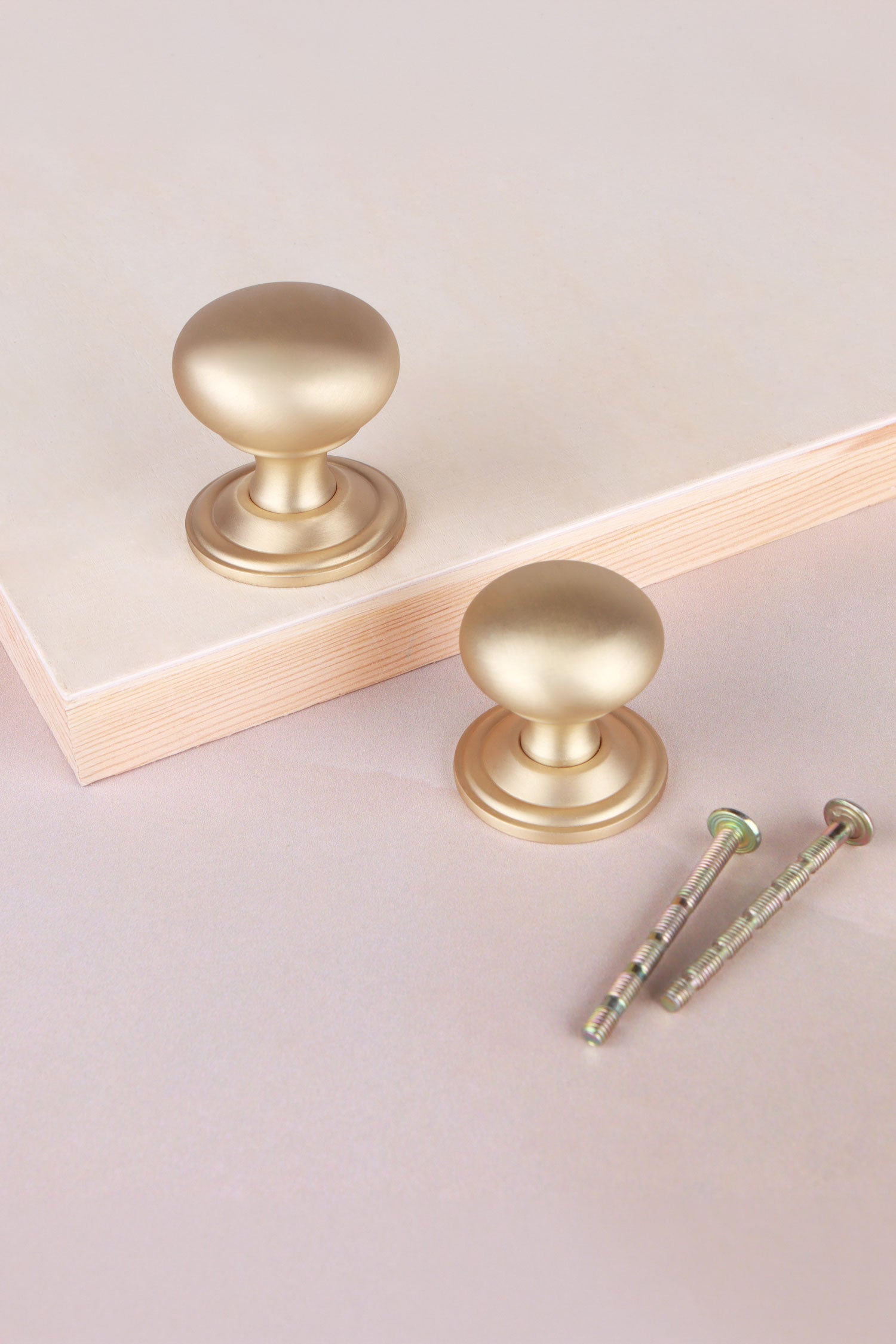 Bun cabinet knob in satin brass, shown in 32mm and 38mm