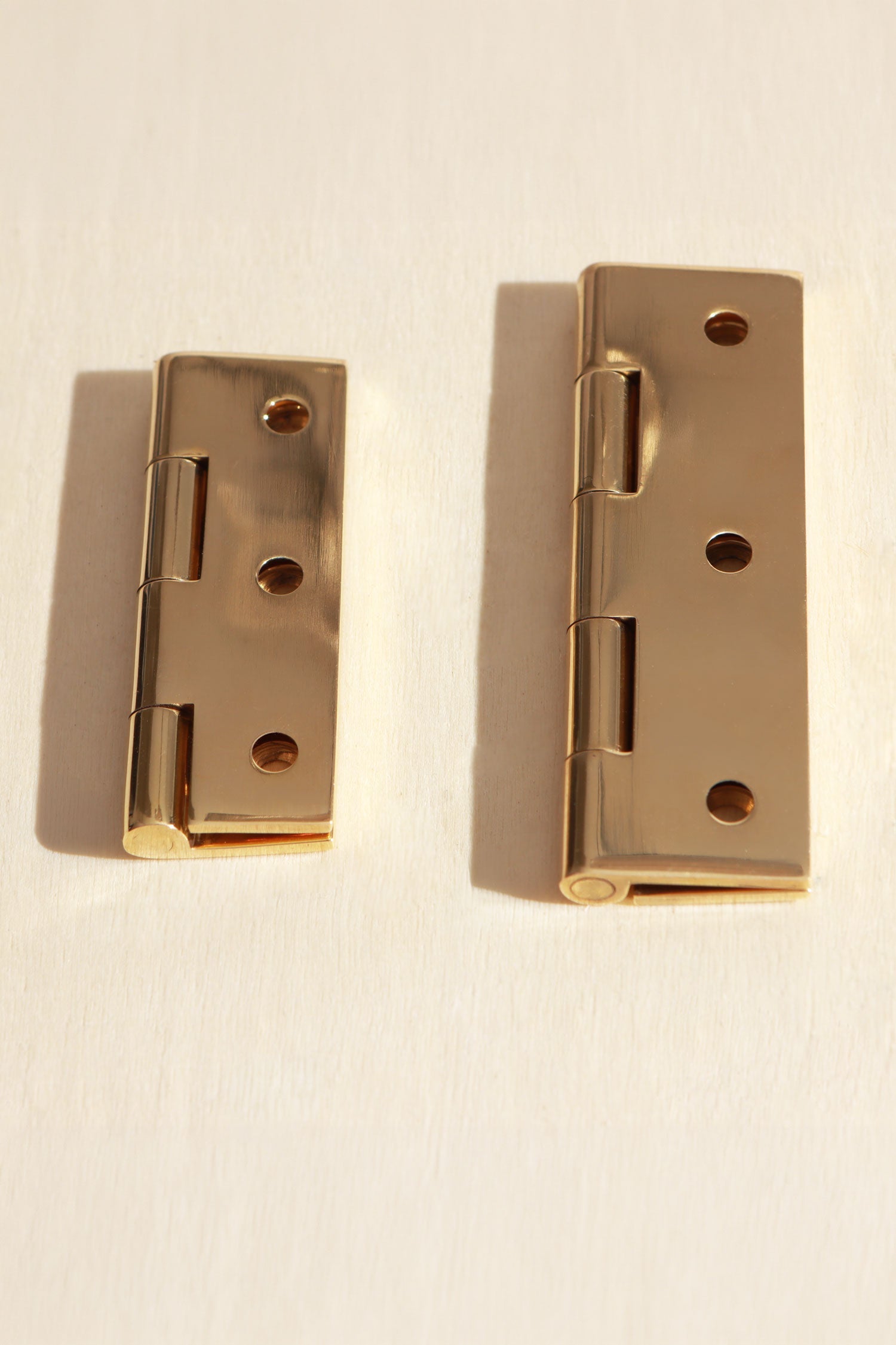 Polished brass butt hinge fitted to a cupboard door