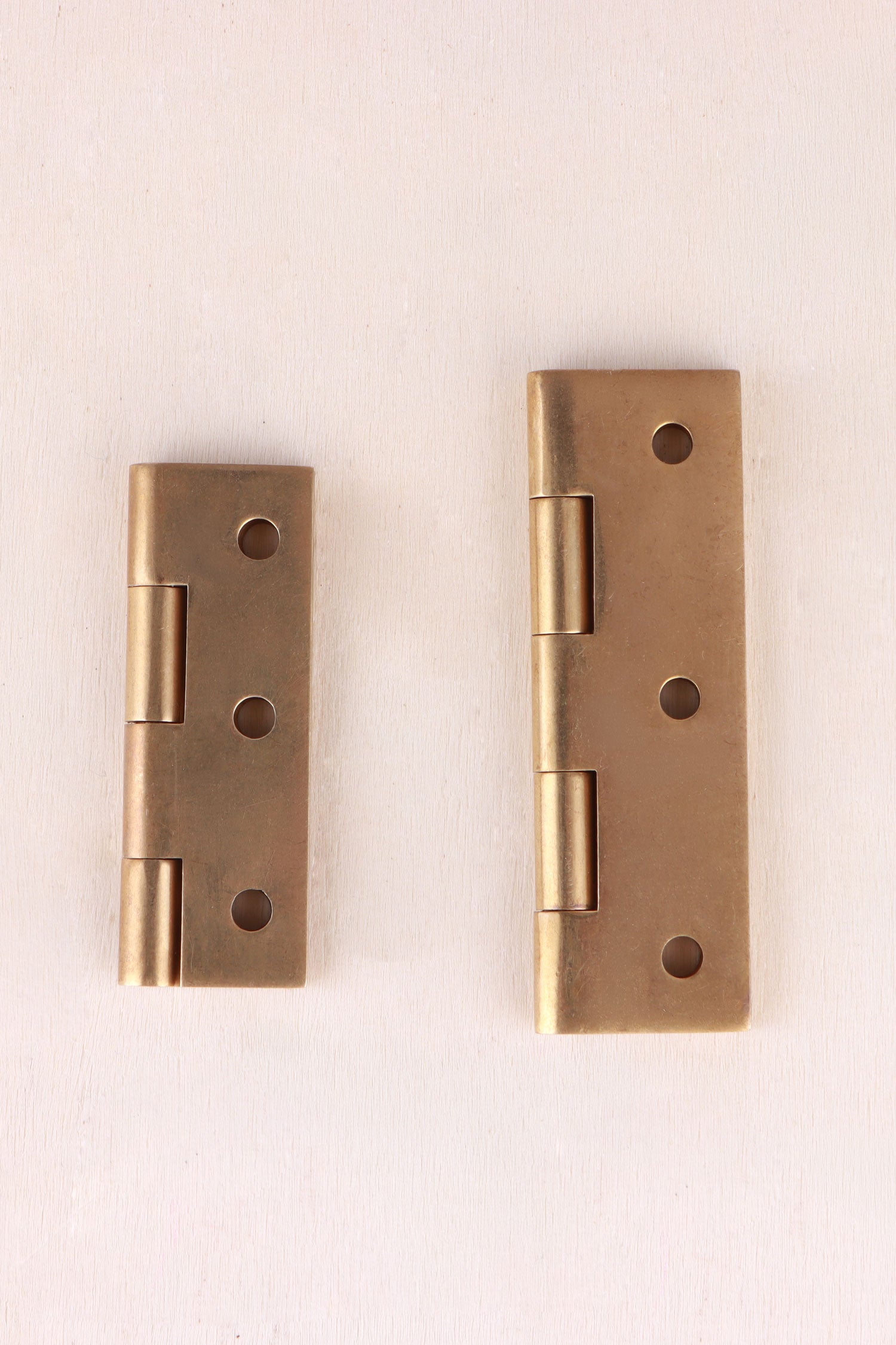 Aged brass butt hinge open, showing the knuckle and solid brass screws