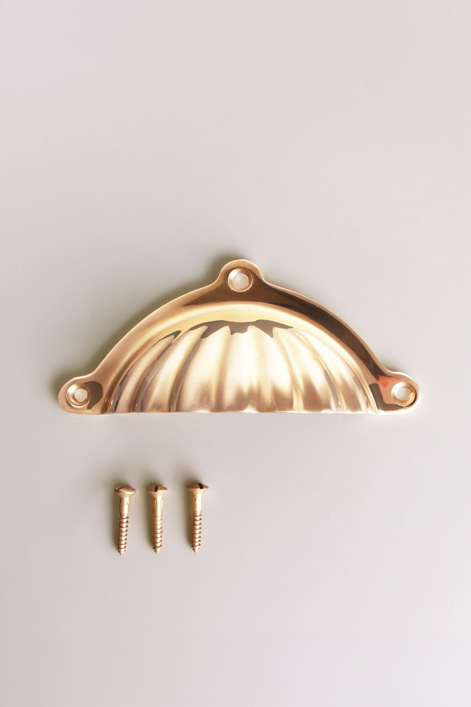 Scalloped cup pull in polished brass, unlacquered living finish