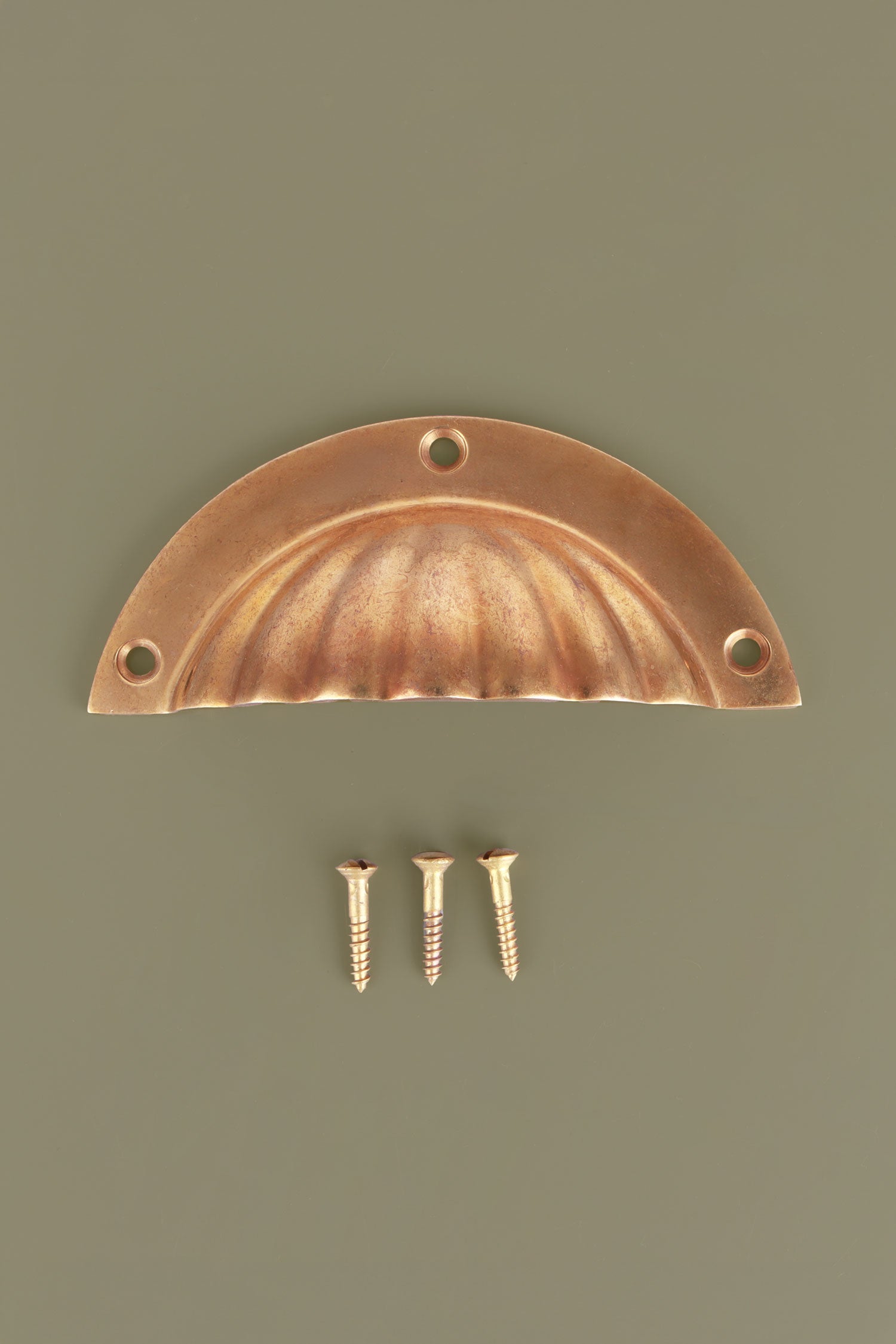 Fluted cup pull in aged brass, unlacquered living finish