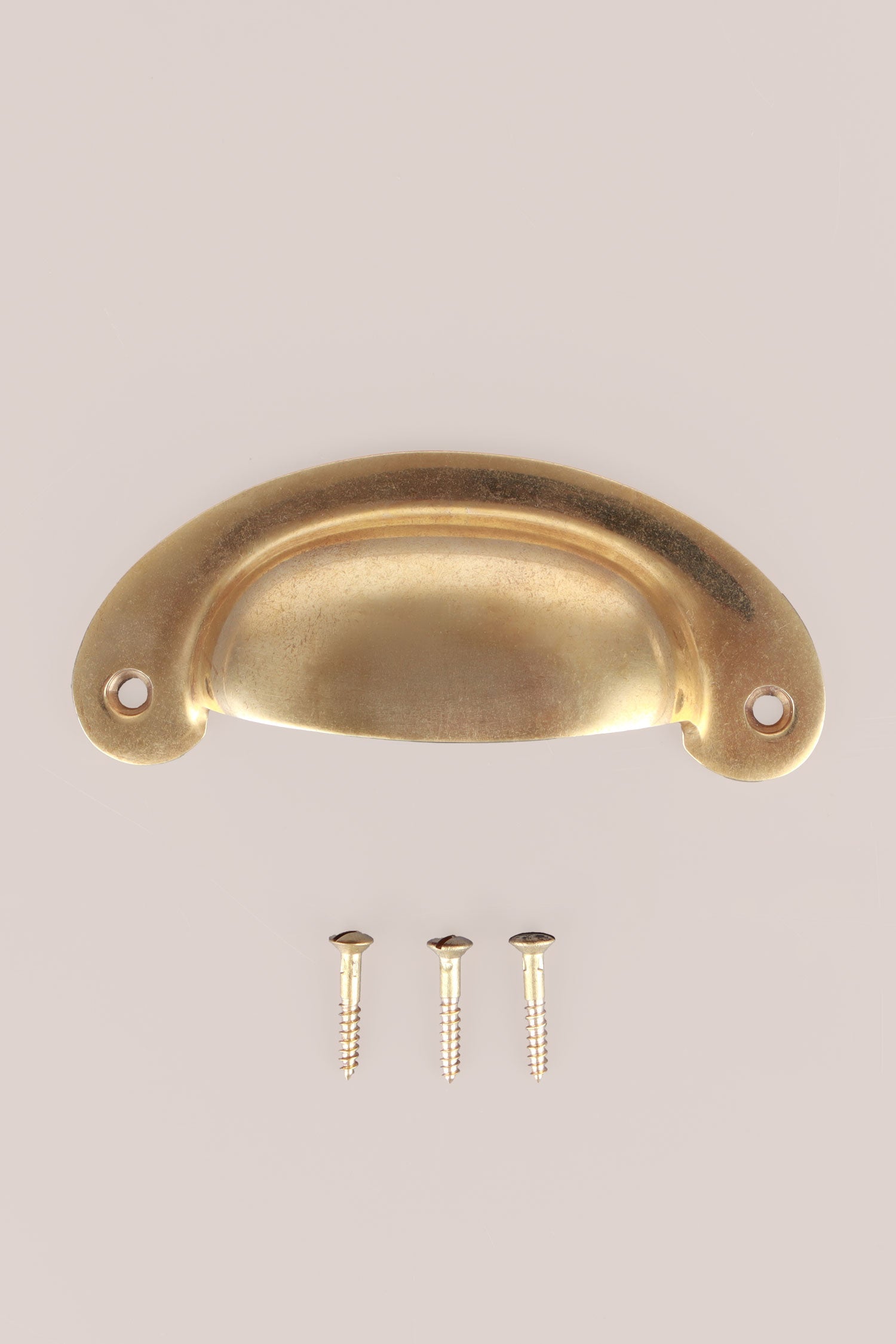 Slim Crescent cup pull in aged brass, unlacquered living finish