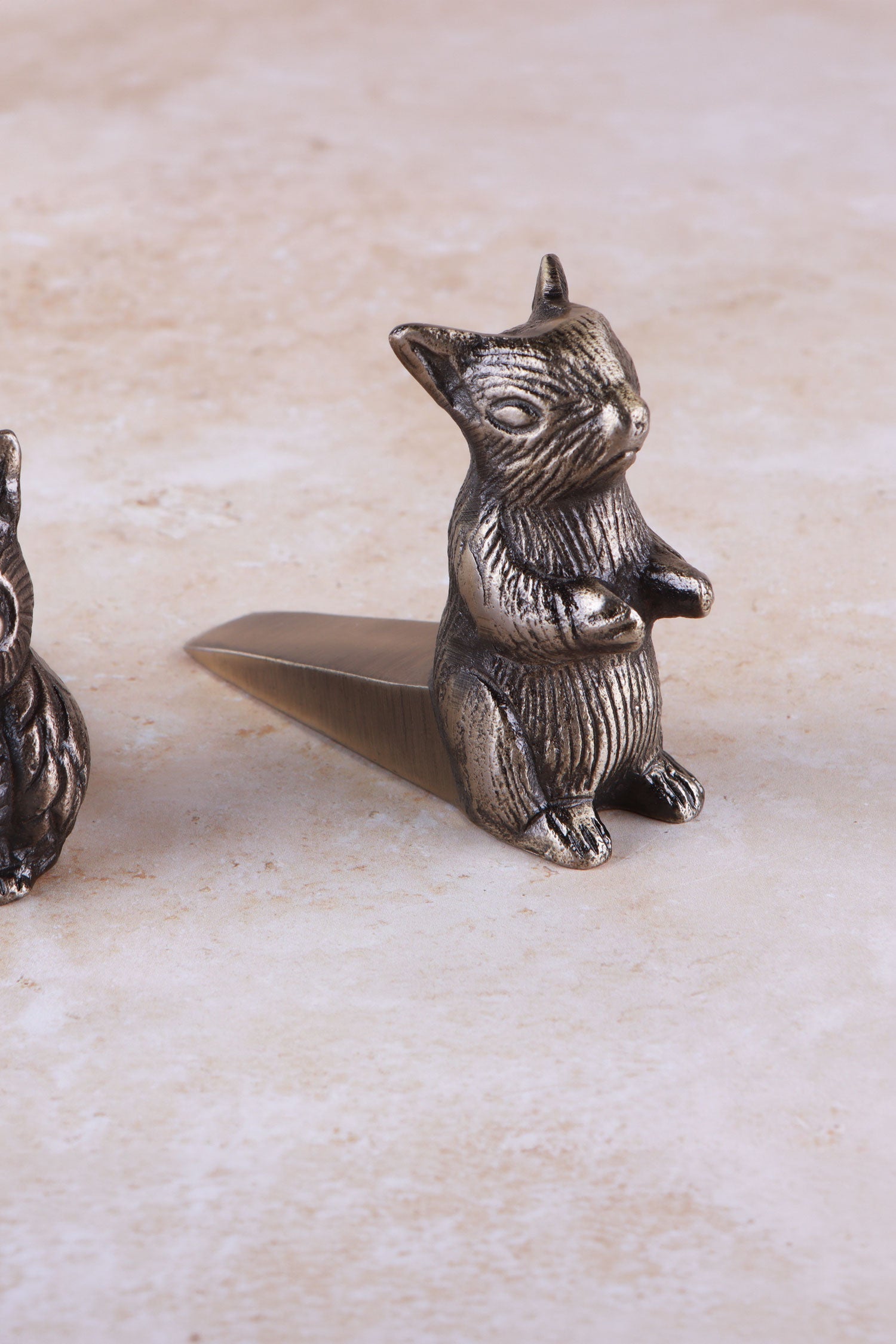 Squirrel door stopper in antique brass, side view