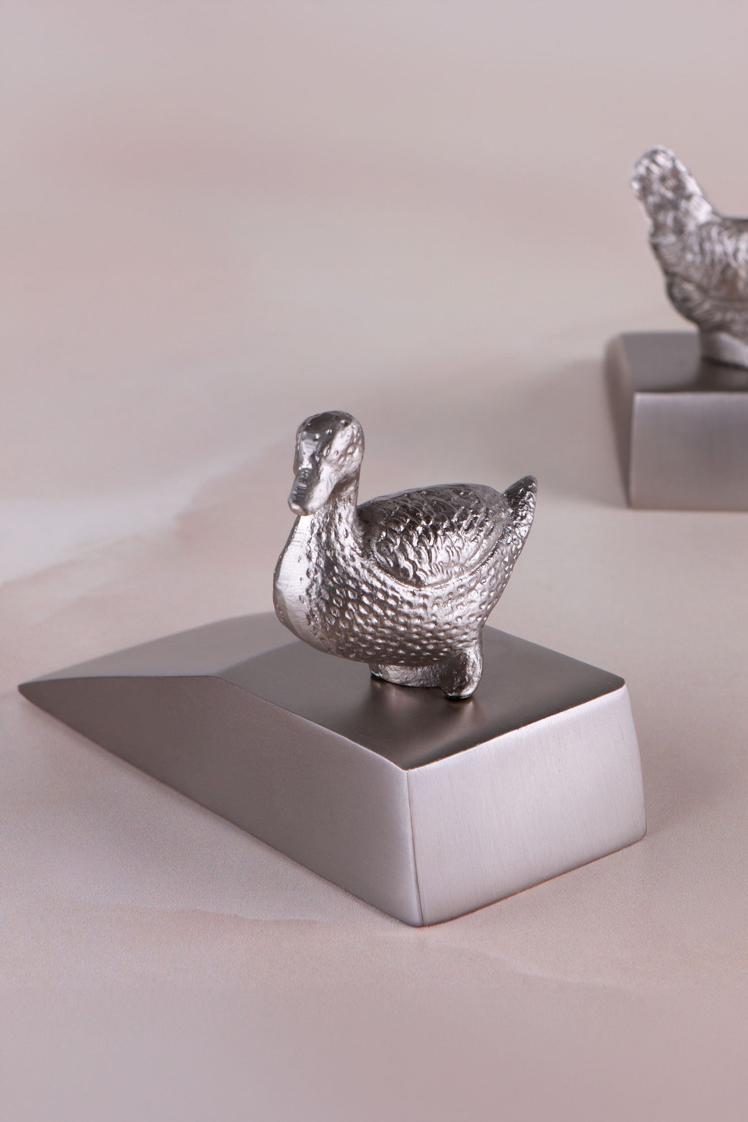 Duck door stopper in chrome on a weighted wedge base