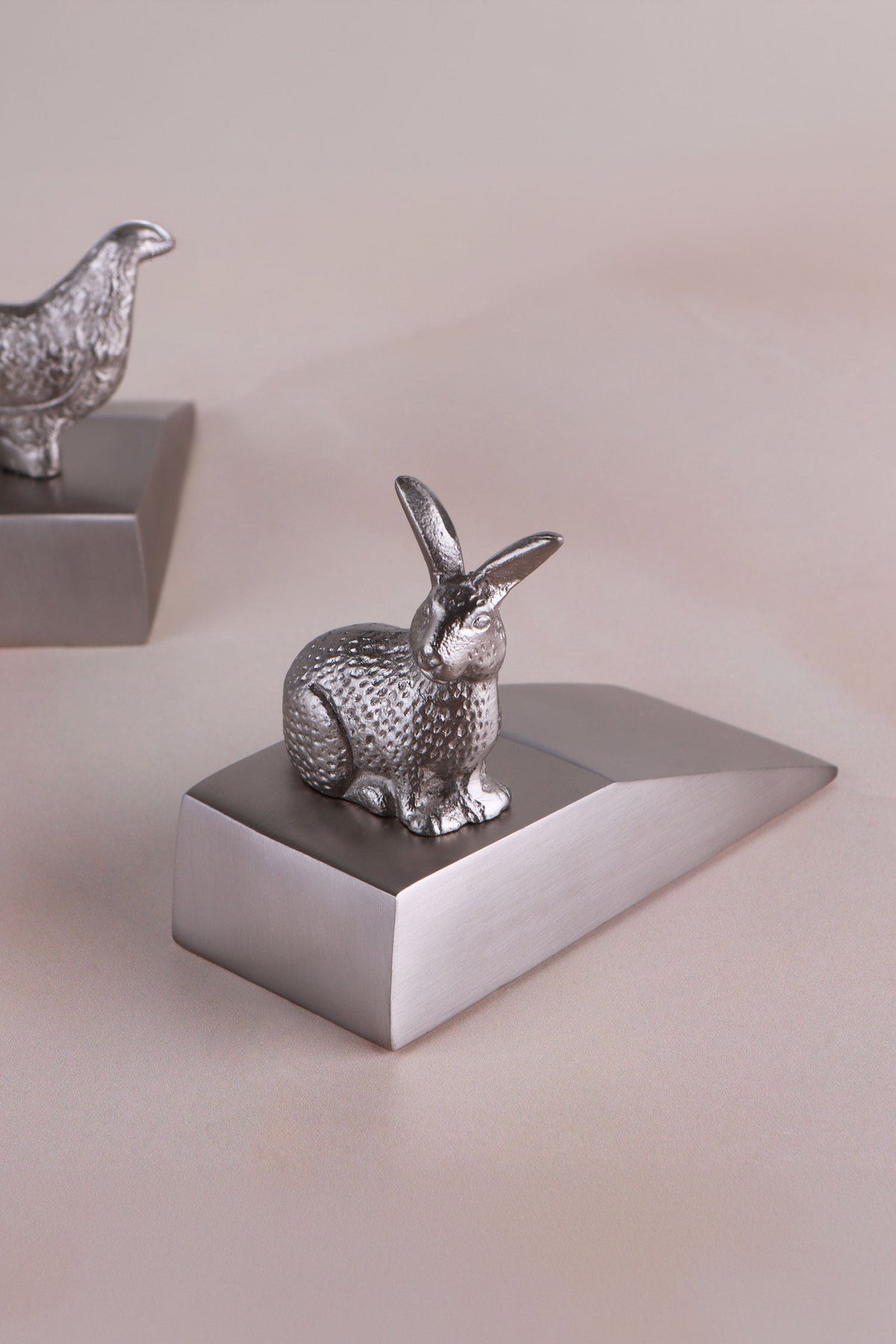 Rabbit door stopper in chrome on a weighted wedge base