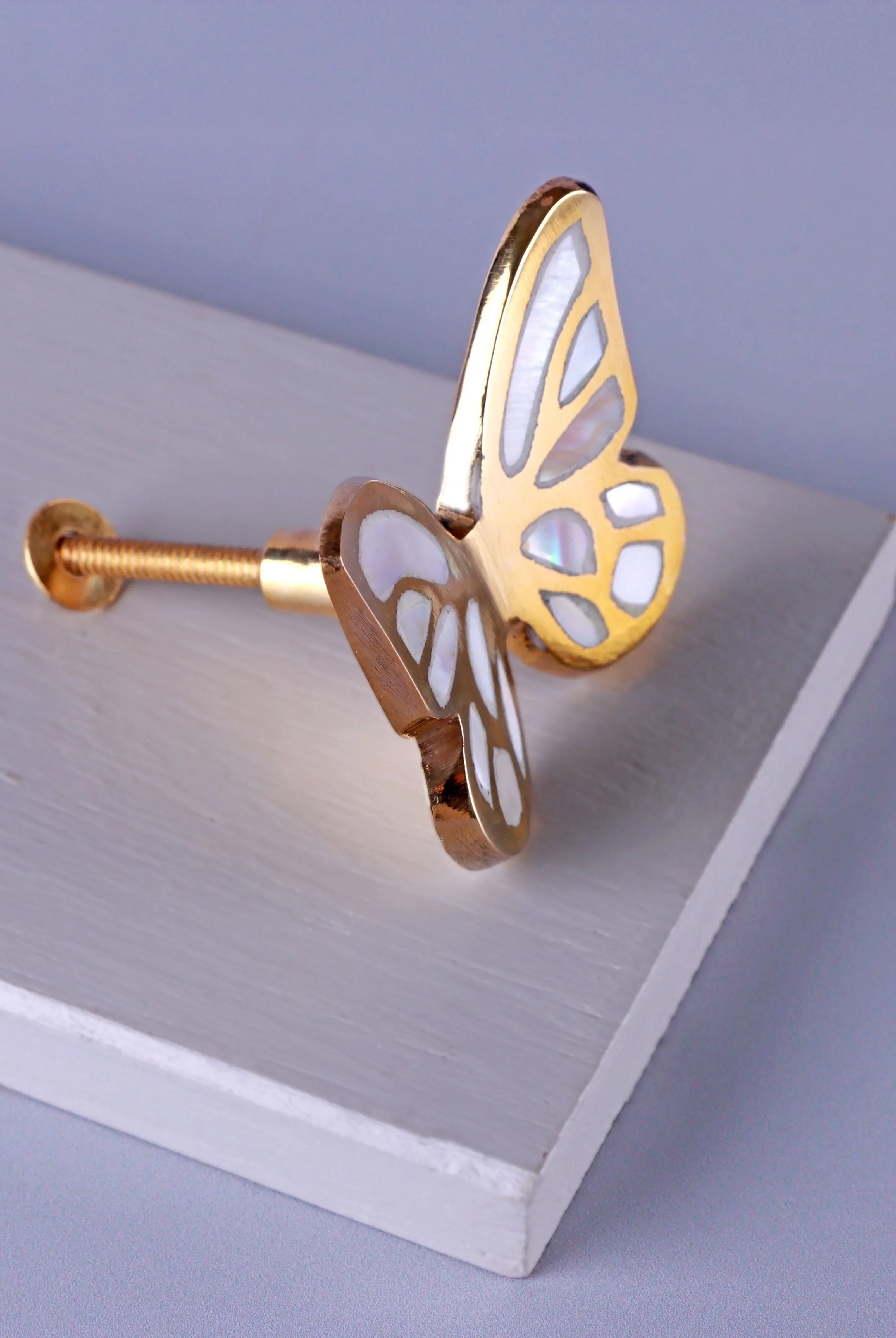 Gold butterfly cabinet knob with white inlay on white board, luxury hardware by G Decor