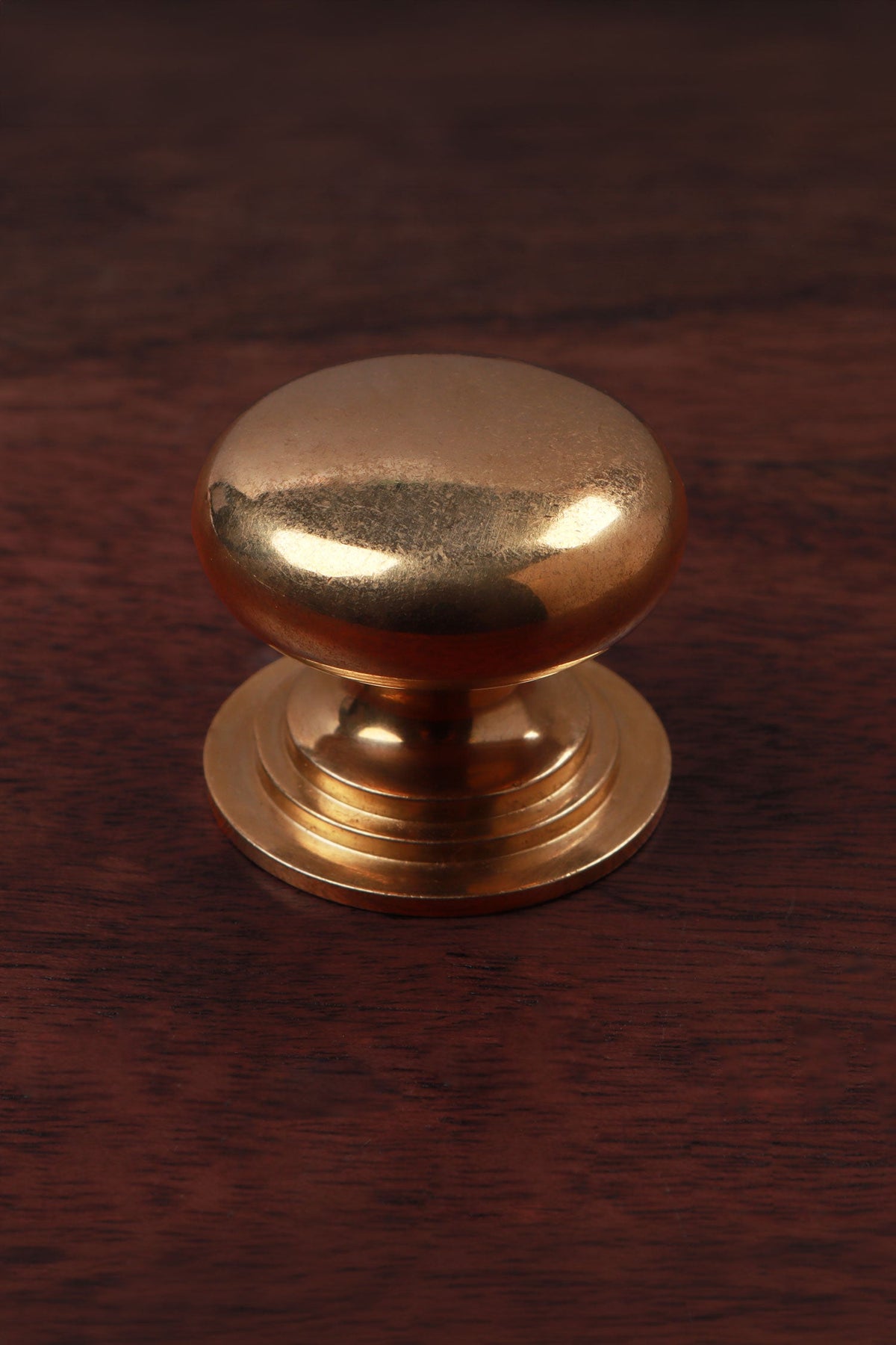 Bun aged brass cabinet knob, domed on a stepped rose, 38mm