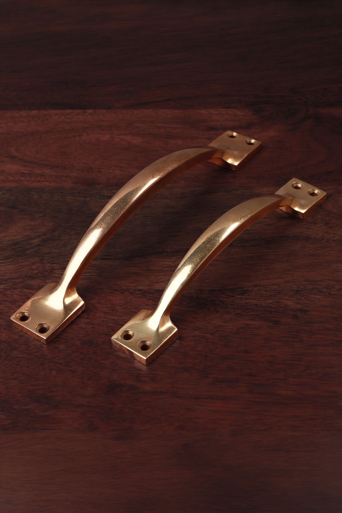 Two aged brass cupboard pull handles, 6 and a quarter inch and 8 and a quarter inch