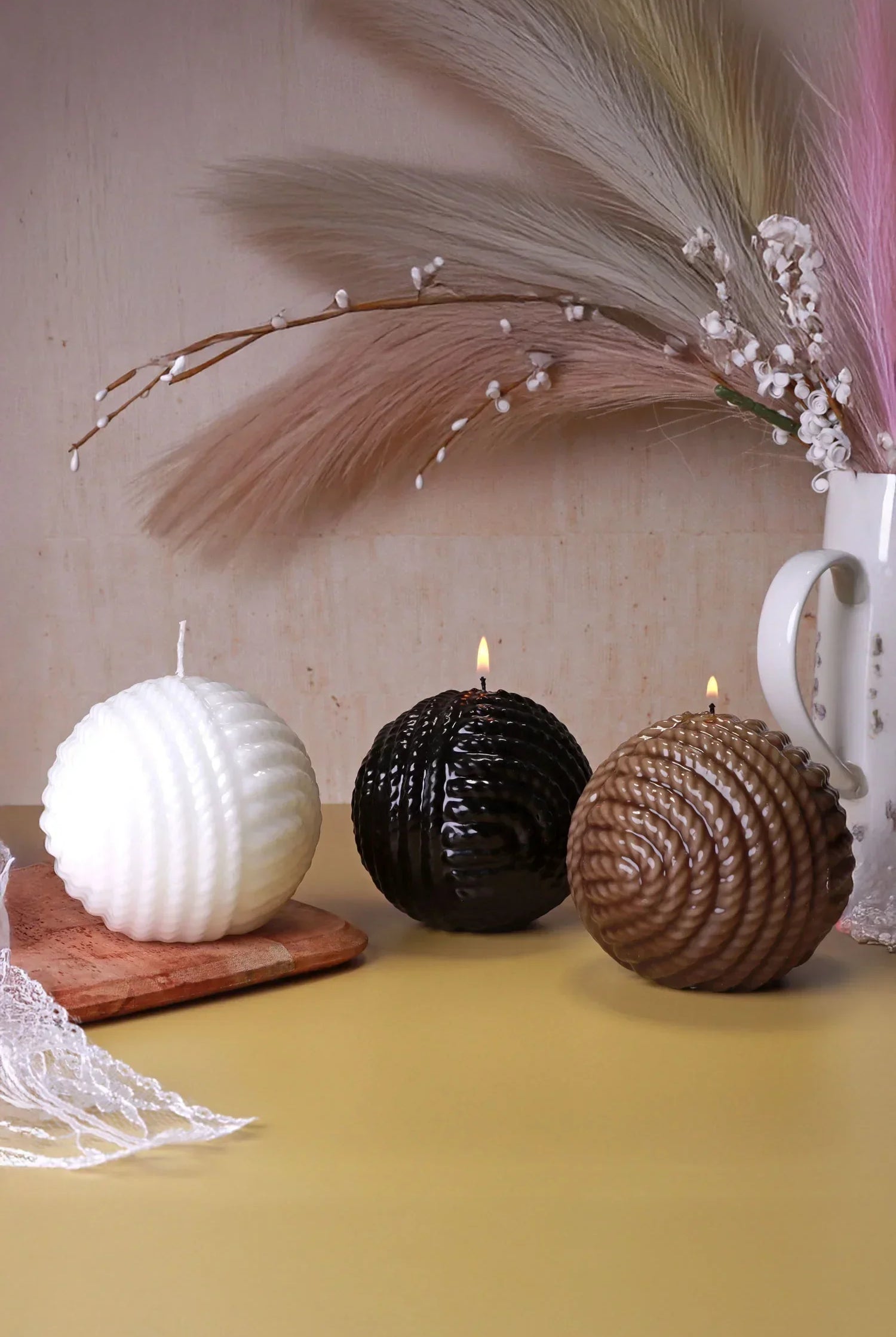 Textured round candles in white, black, and brown by G Decor, styled with pampas grass.