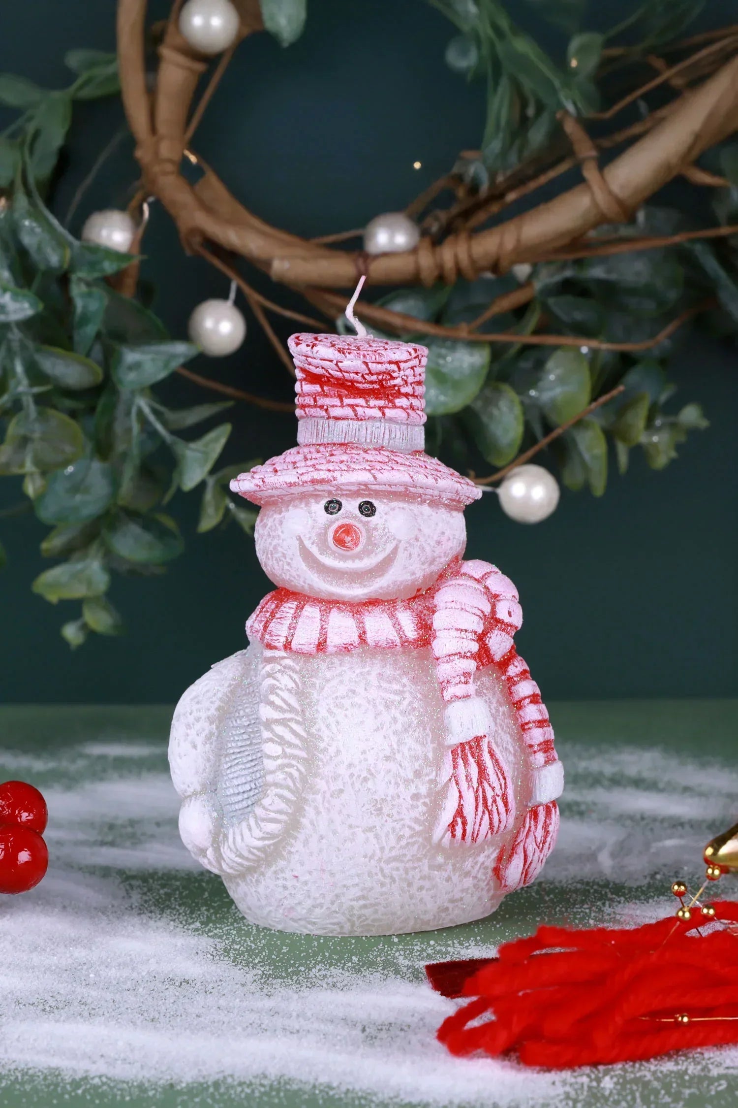 Festive snowman candle with red hat and scarf, surrounded by holiday décor from G Decor.