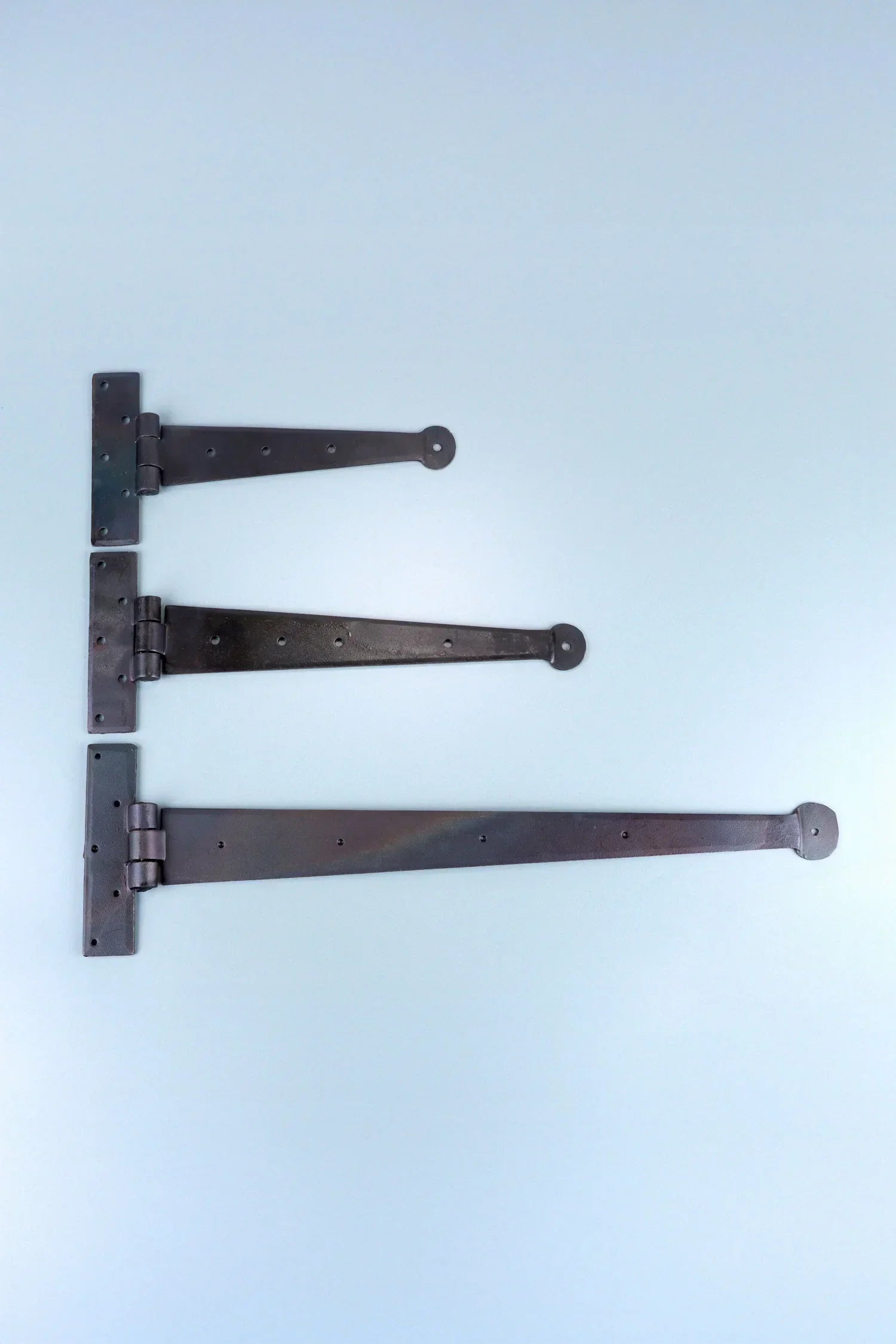 Set of three black metal T-hinges displayed on a light blue background, G Decor hardware