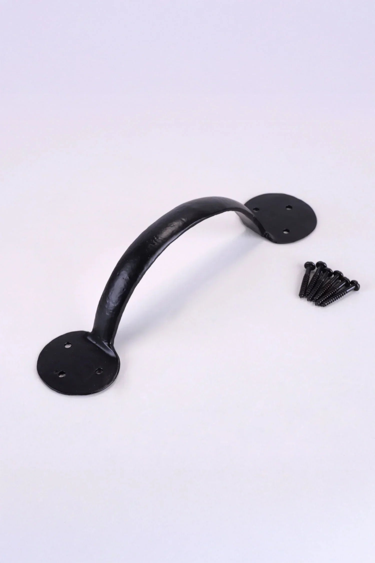 Black metal door pull handle with screws on white background, G Decor luxury hardware