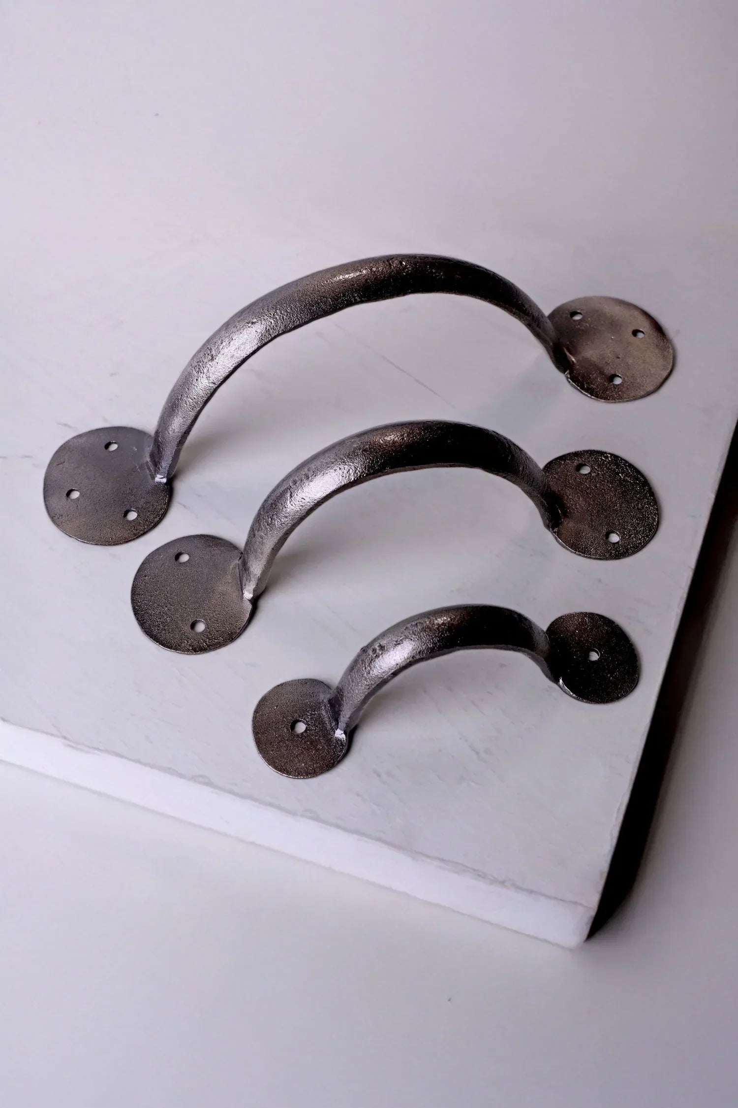 Set of three metallic cabinet handles in varying sizes on white background from G Decor