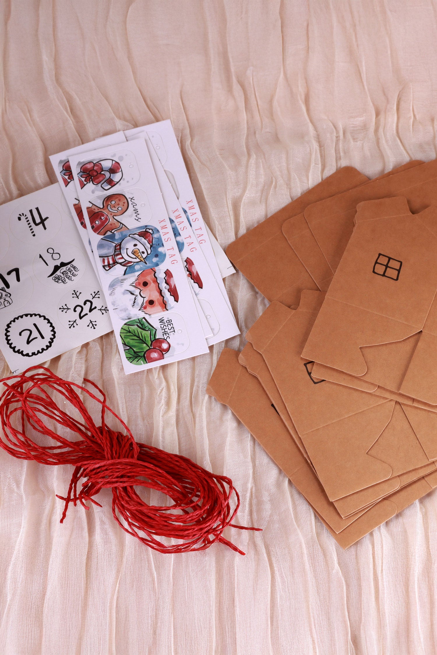 G Decor Christmas craft kit with brown house-shaped cards, red string, and festive stickers.