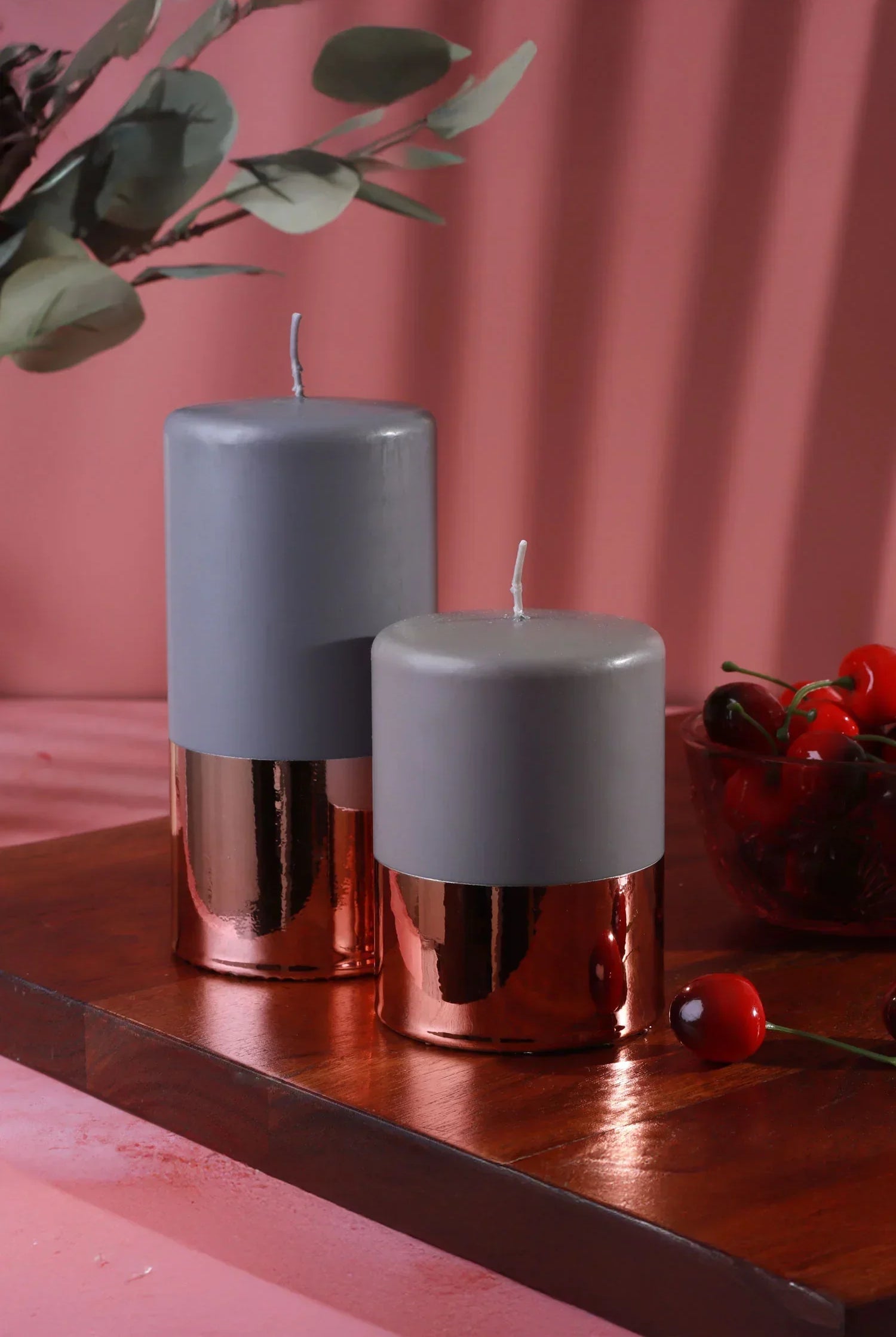 Grey and rose gold luxury pillar candles by G Decor, styled on a wooden tray with cherries
