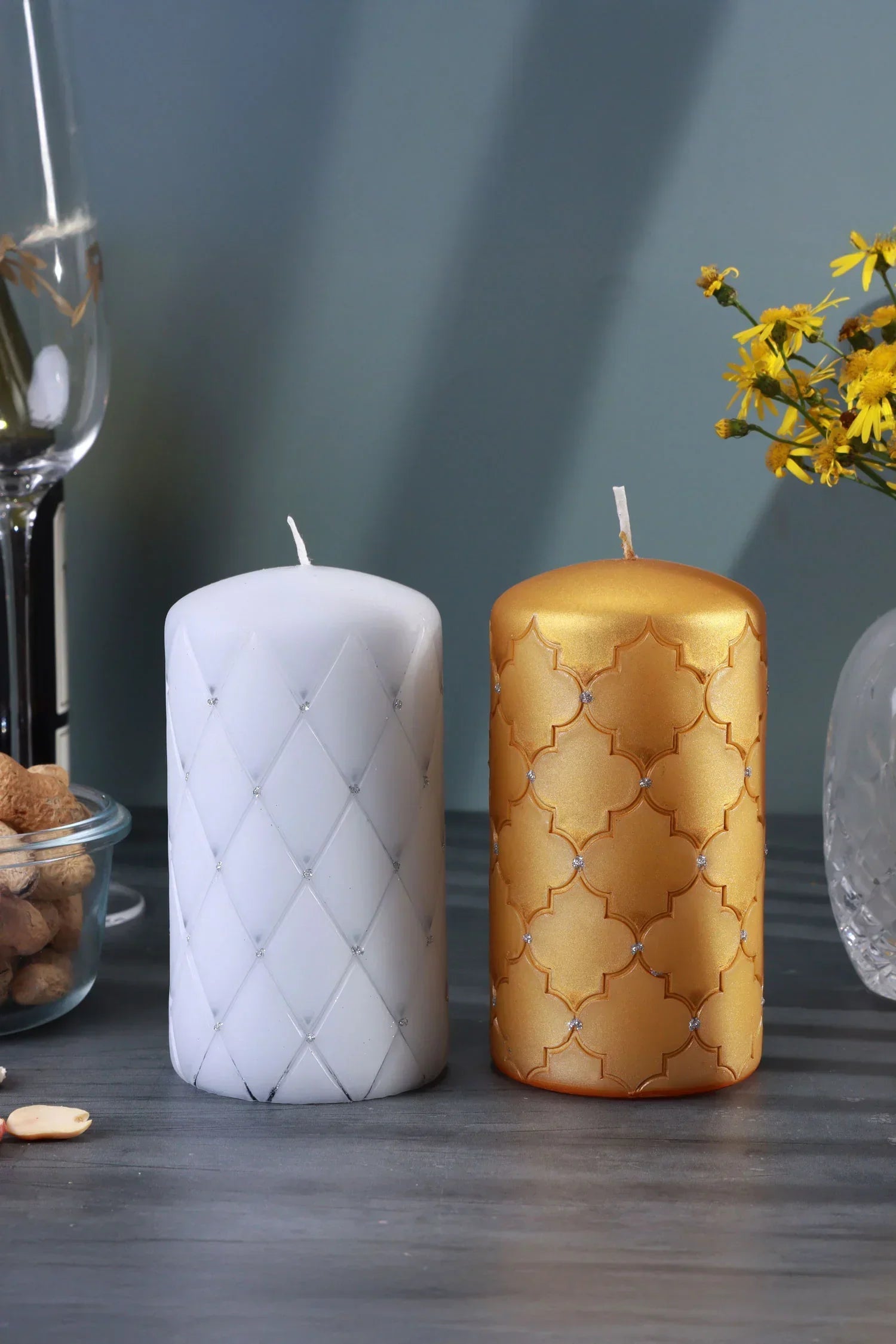 Luxury white and gold decorative candles by G Decor on a modern table with glassware and flowers