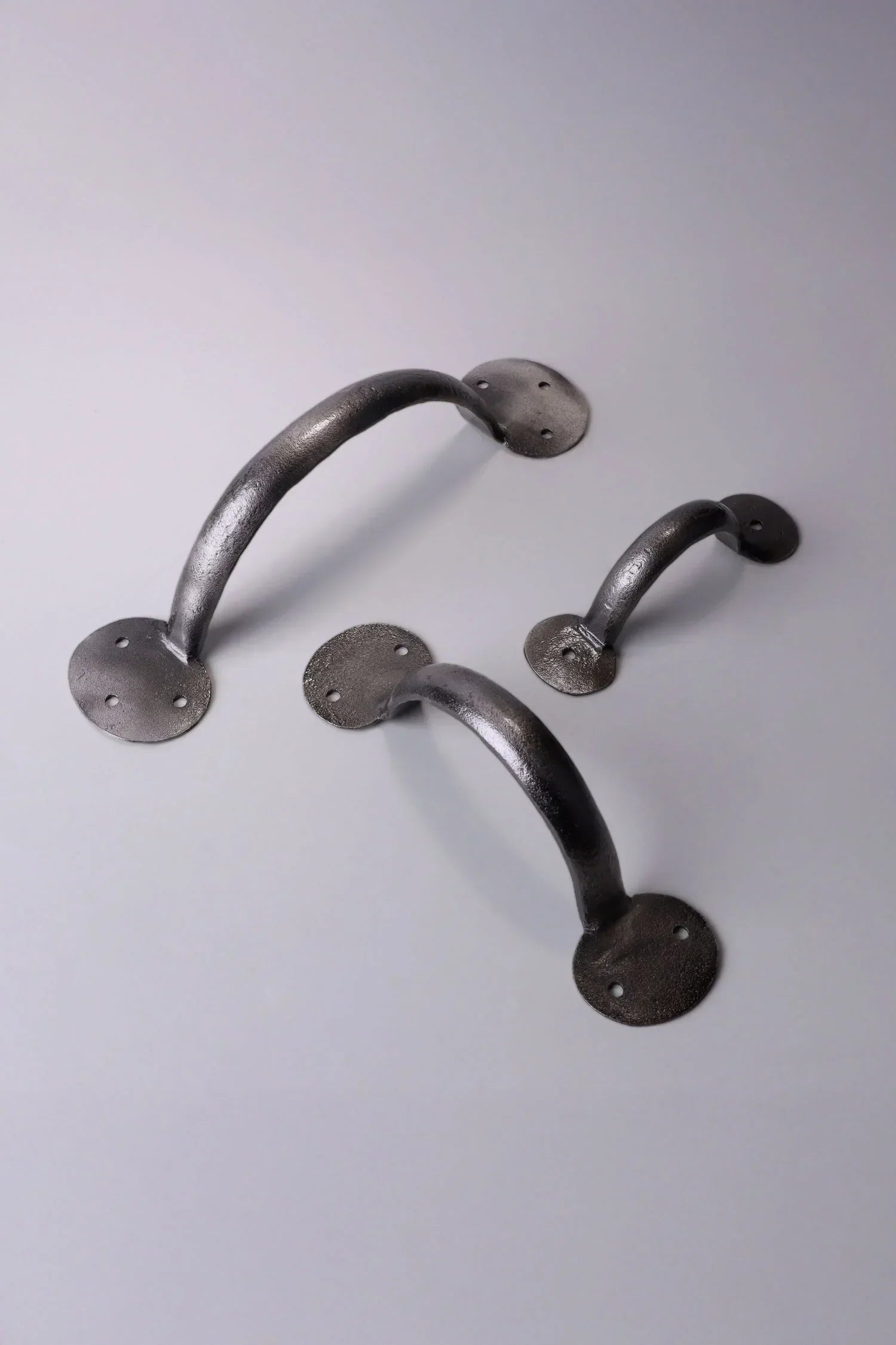 Set of three rustic metal cabinet handles by G Decor on a light background