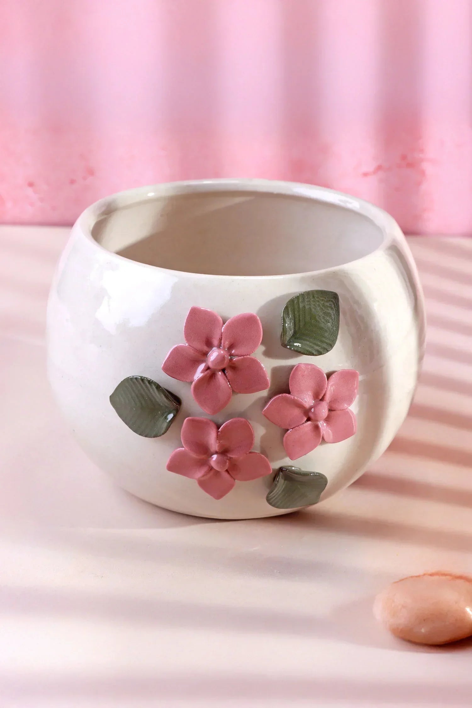 White ceramic flower pot with pink floral and green leaf accents, G Decor home décor