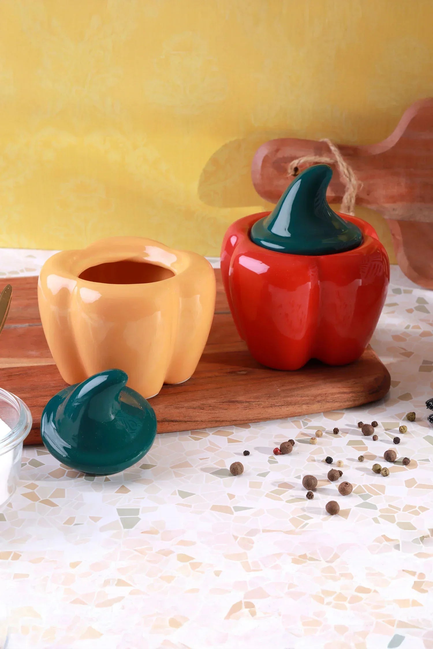 Colorful ceramic pepper-shaped condiment jars on a wooden board, G Decor kitchenware.