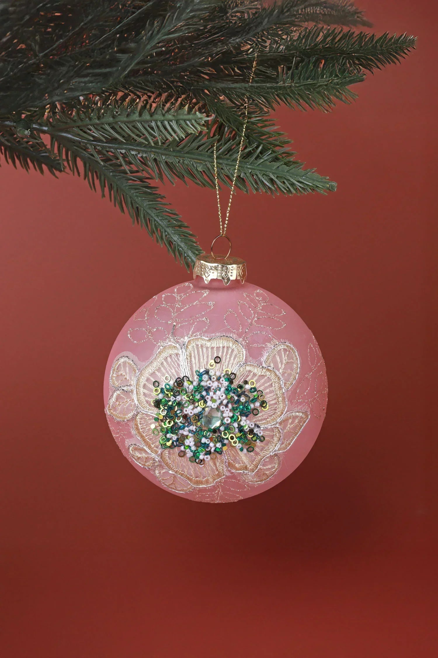 Pink floral Christmas bauble with sequins hanging on pine branch, luxury decor by G Decor