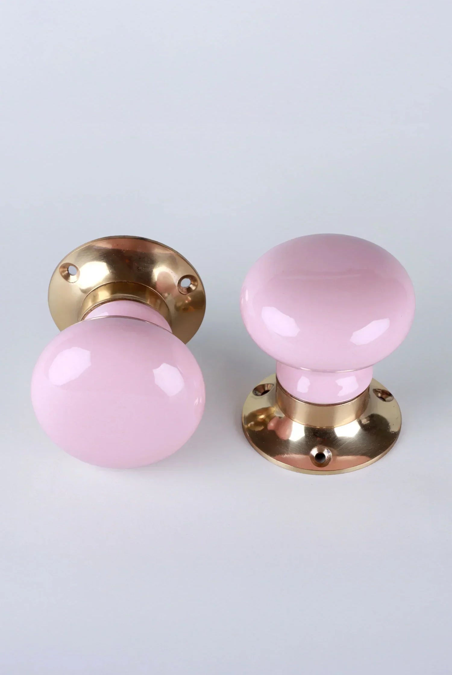 Pair of pink and gold luxury door knobs from G Decor on a white background