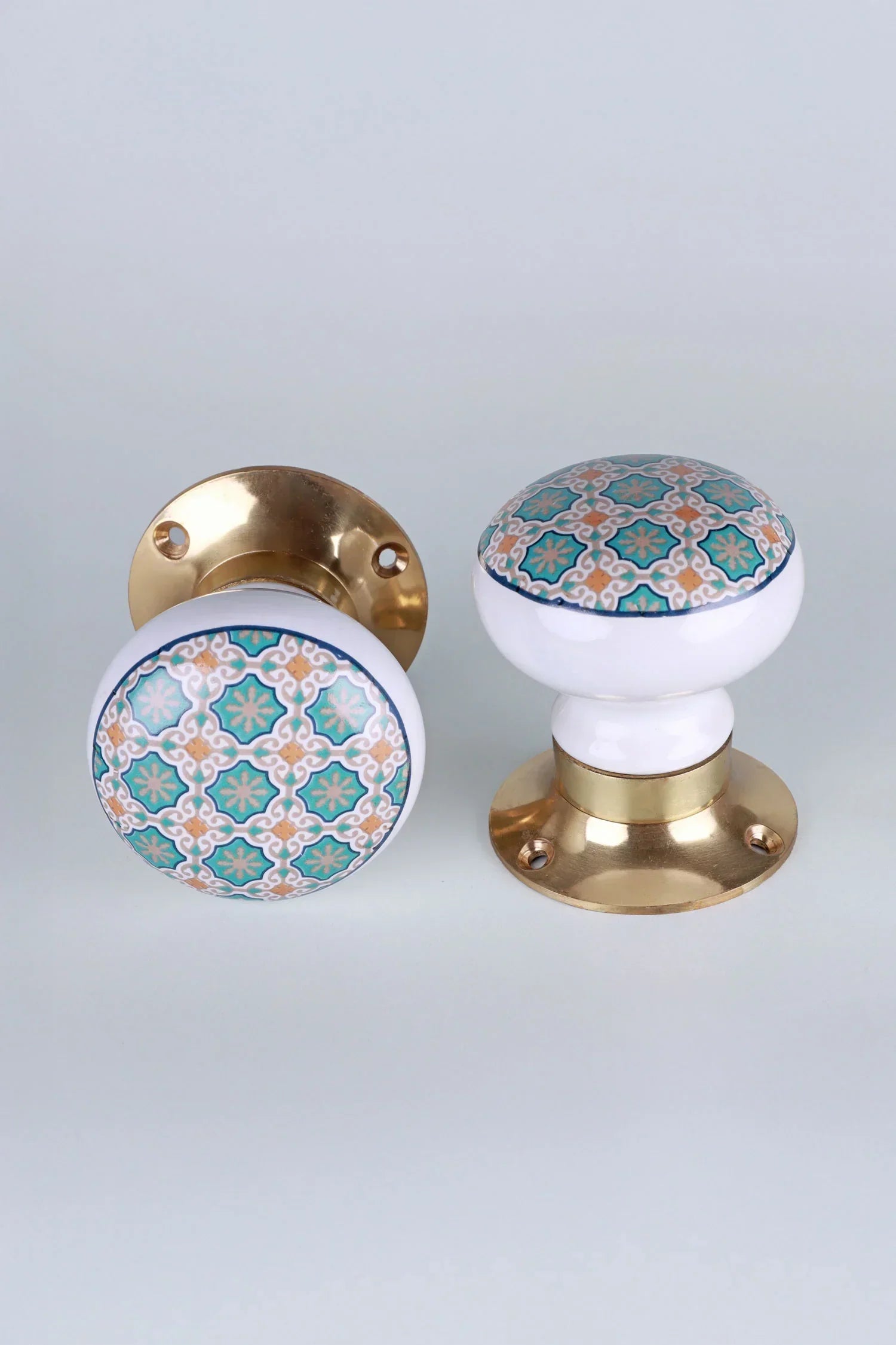Pair of G Decor ceramic and brass cabinet knobs with intricate teal and gold pattern