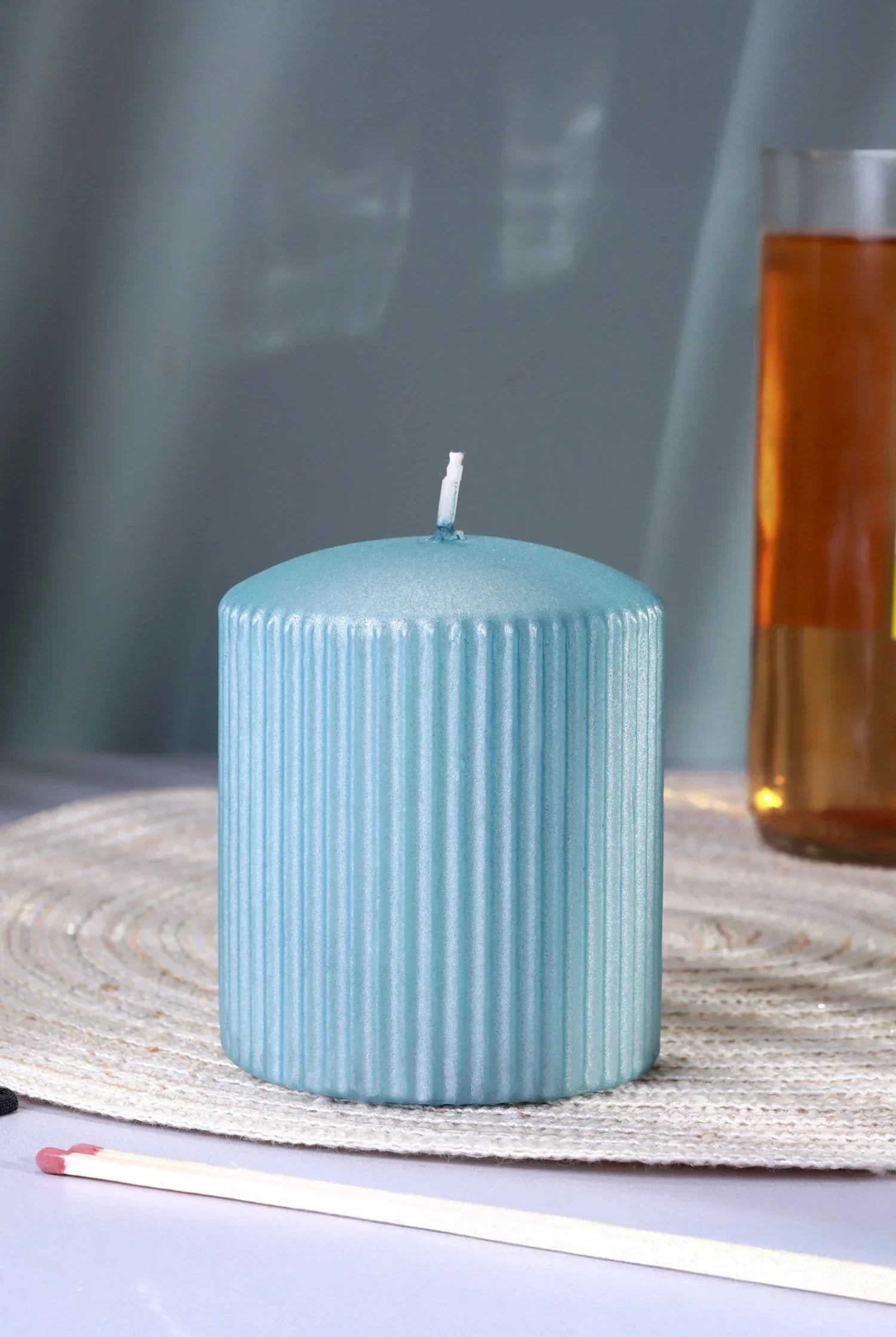 Blue ribbed pillar candle from G Decor on a woven placemat, luxury home décor accent