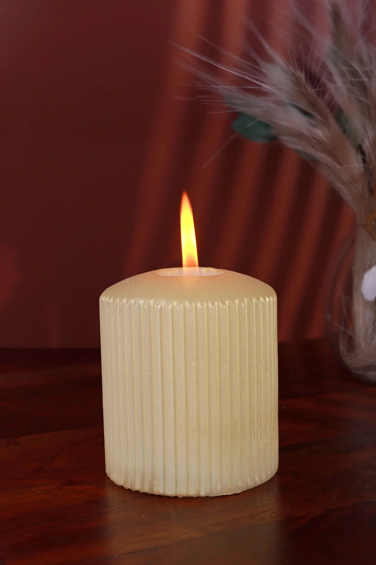 Textured cream pillar candle burning on wooden surface, luxury G Decor home accessory