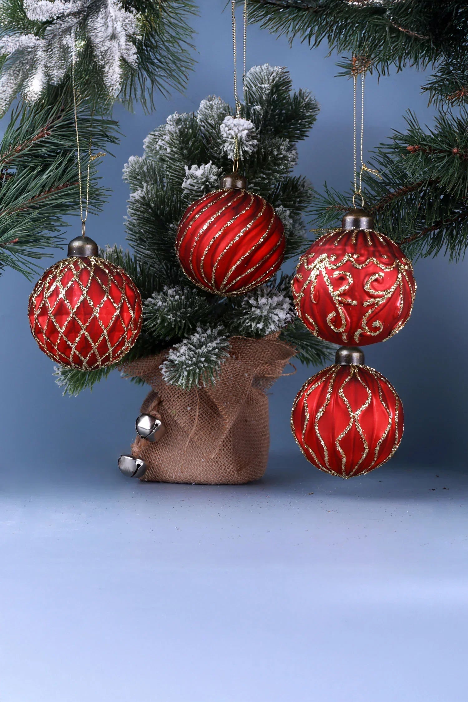 Red and gold Christmas baubles on frosted pine branches, festive decor by G Decor