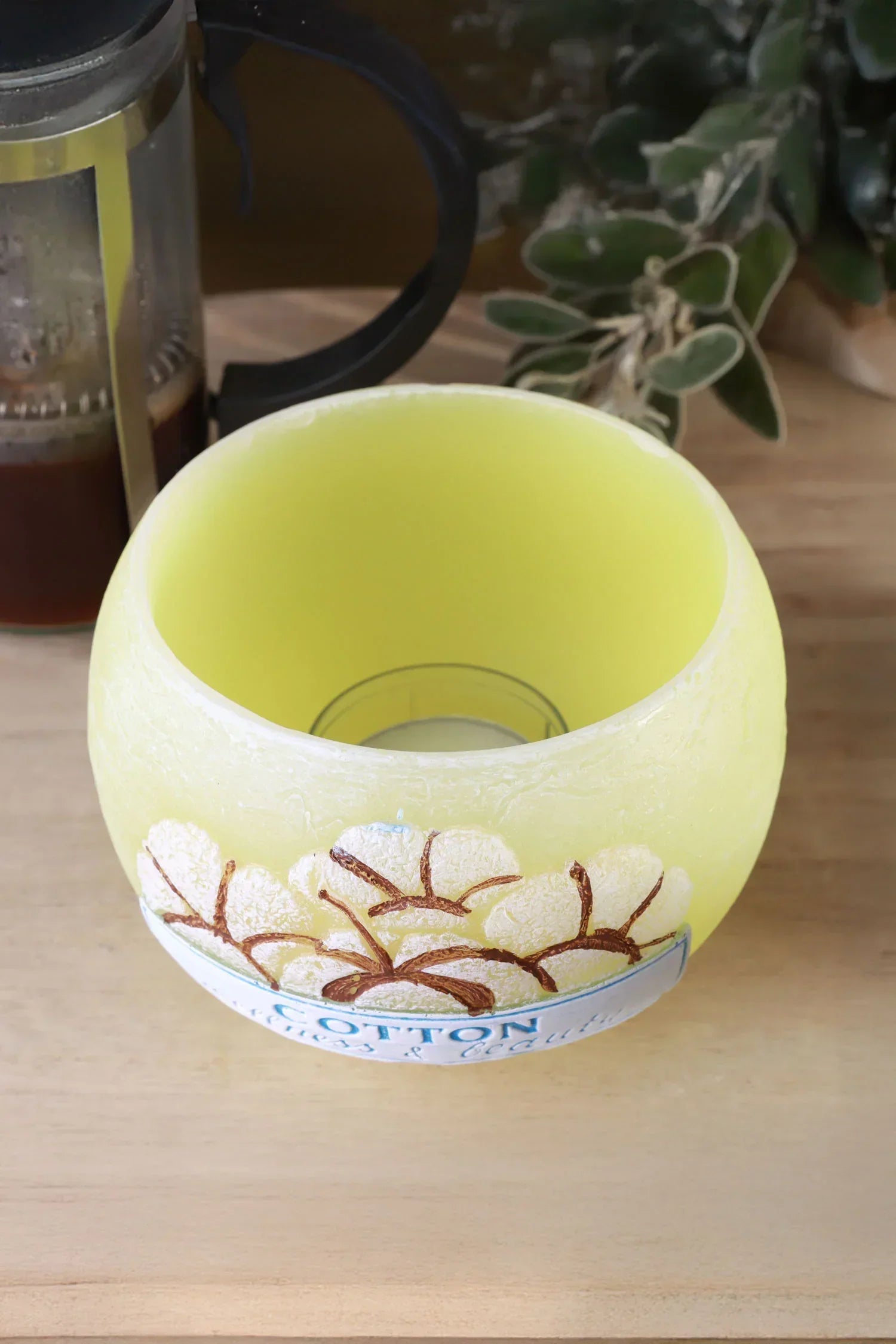 Yellow round candle holder with cotton plant design on wood table, G Decor home décor.