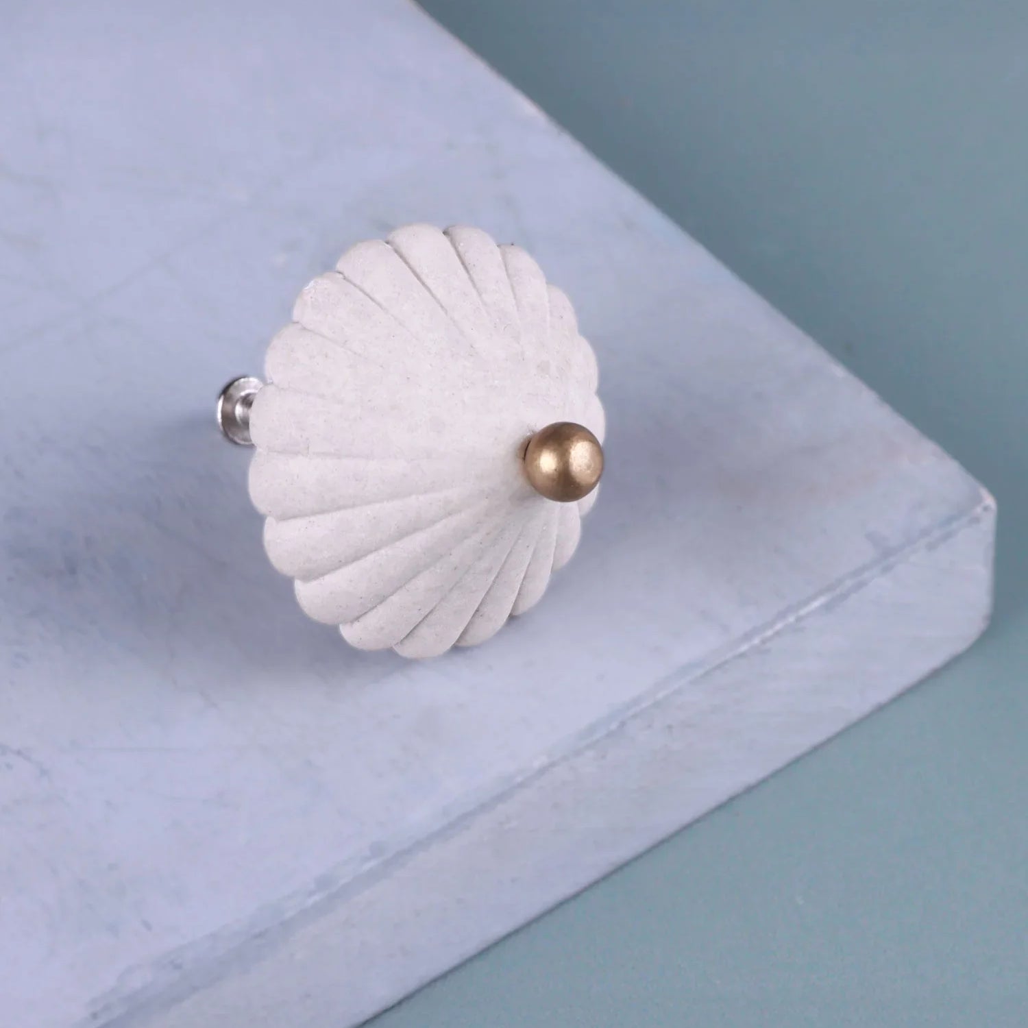 Luxury white scalloped cabinet knob with gold accent by G Decor on blue surface