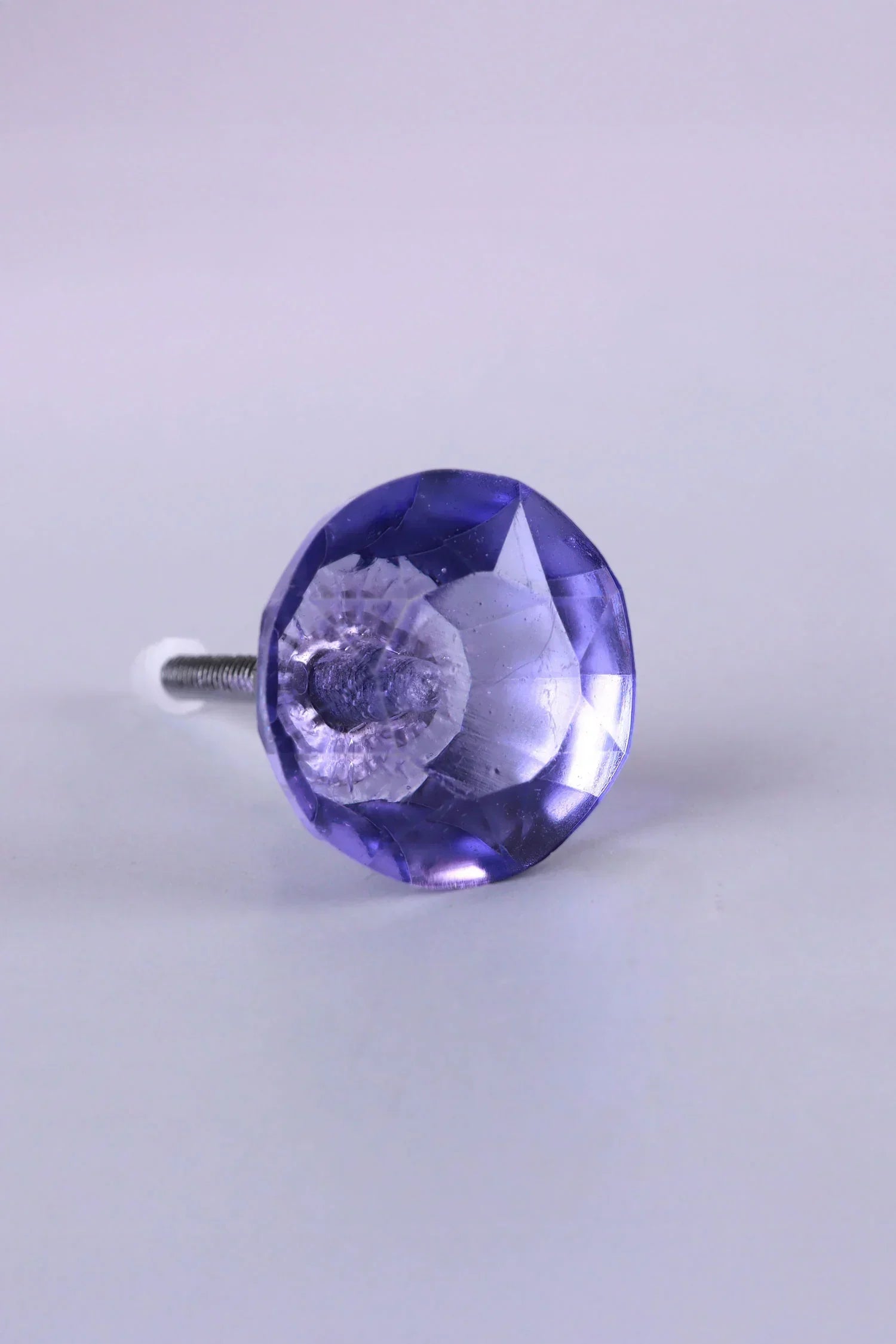 Faceted purple crystal drawer knob with silver hardware on plain background, G Decor luxury hardware