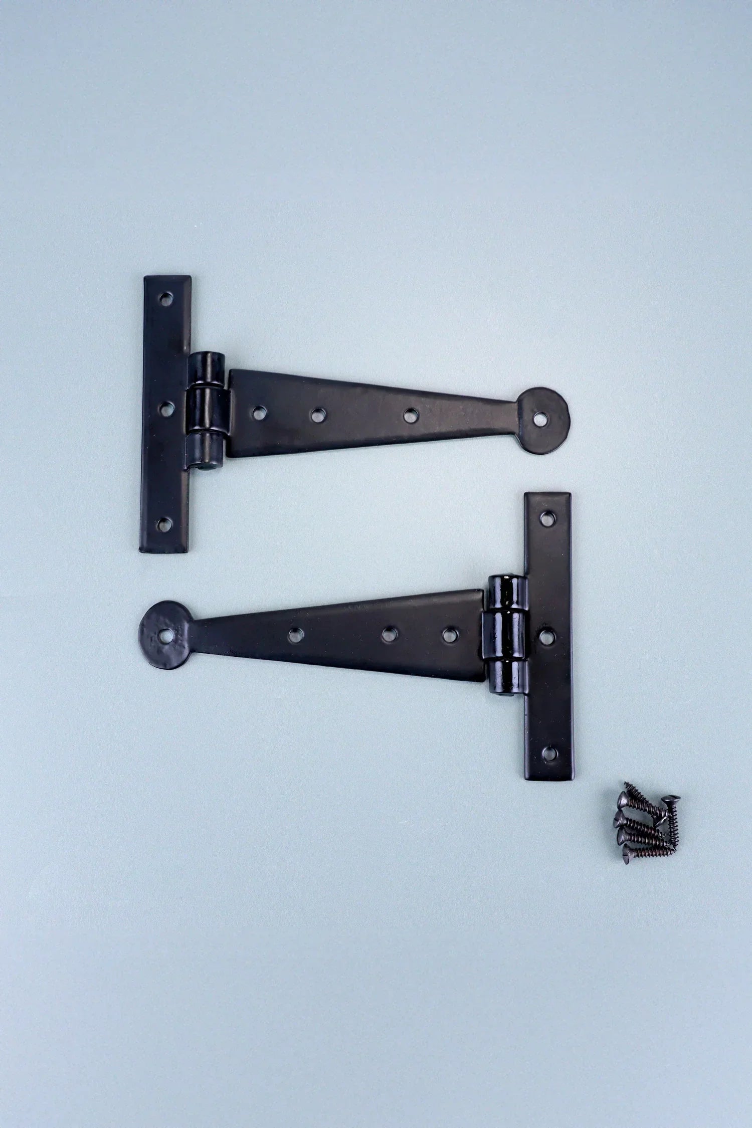 Black metal T-hinges with screws on a light background, luxury hardware by G Decor