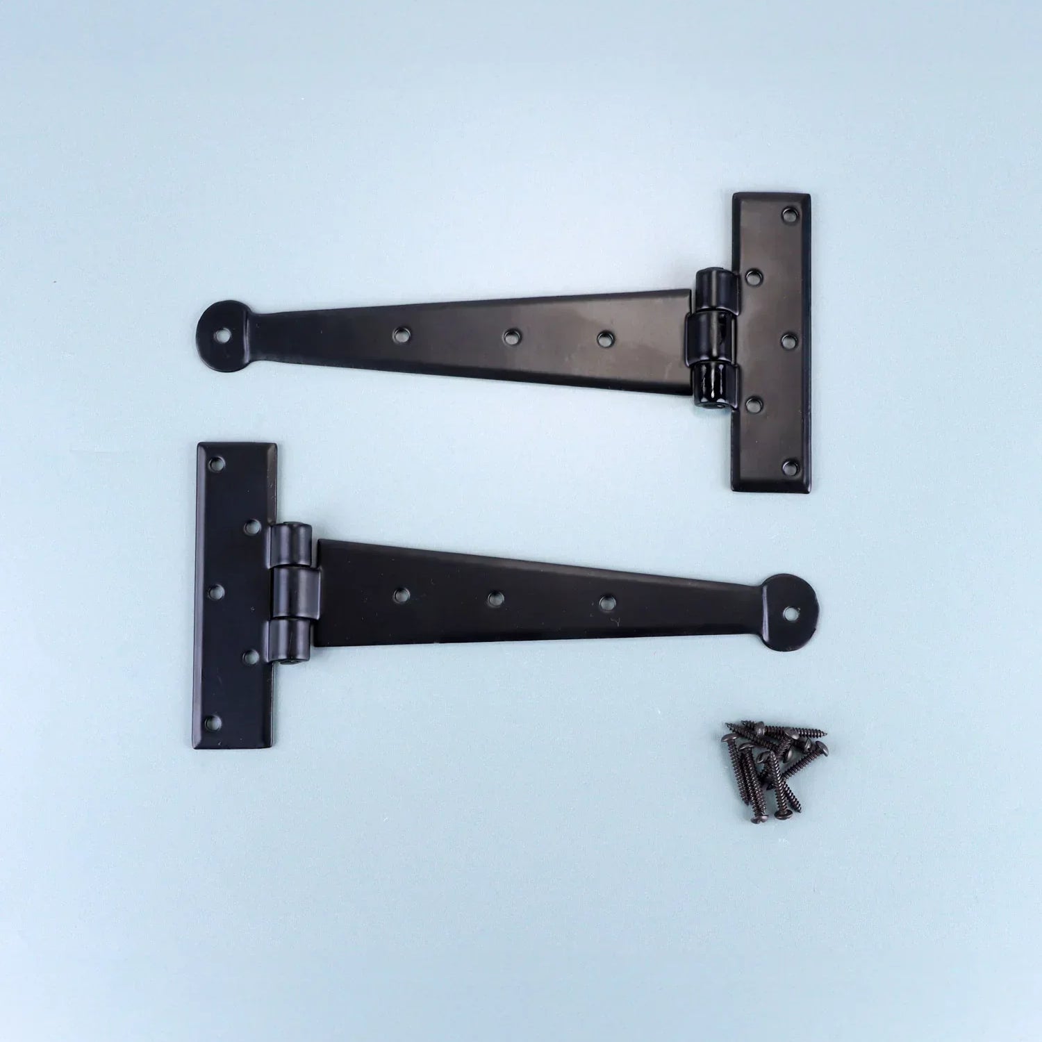 Pair of black T hinge brackets with screws, G Decor luxury hardware on light blue background.