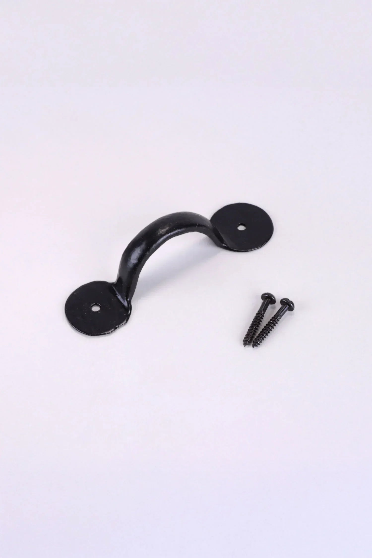 Black metal pull handle with two matching screws for kitchen or interior hardware by G Decor