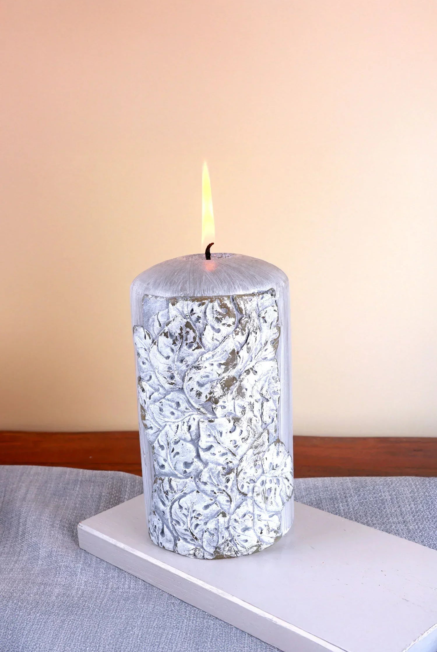 Decorative silver pillar candle with embossed leaf design on table, luxury G Decor home décor