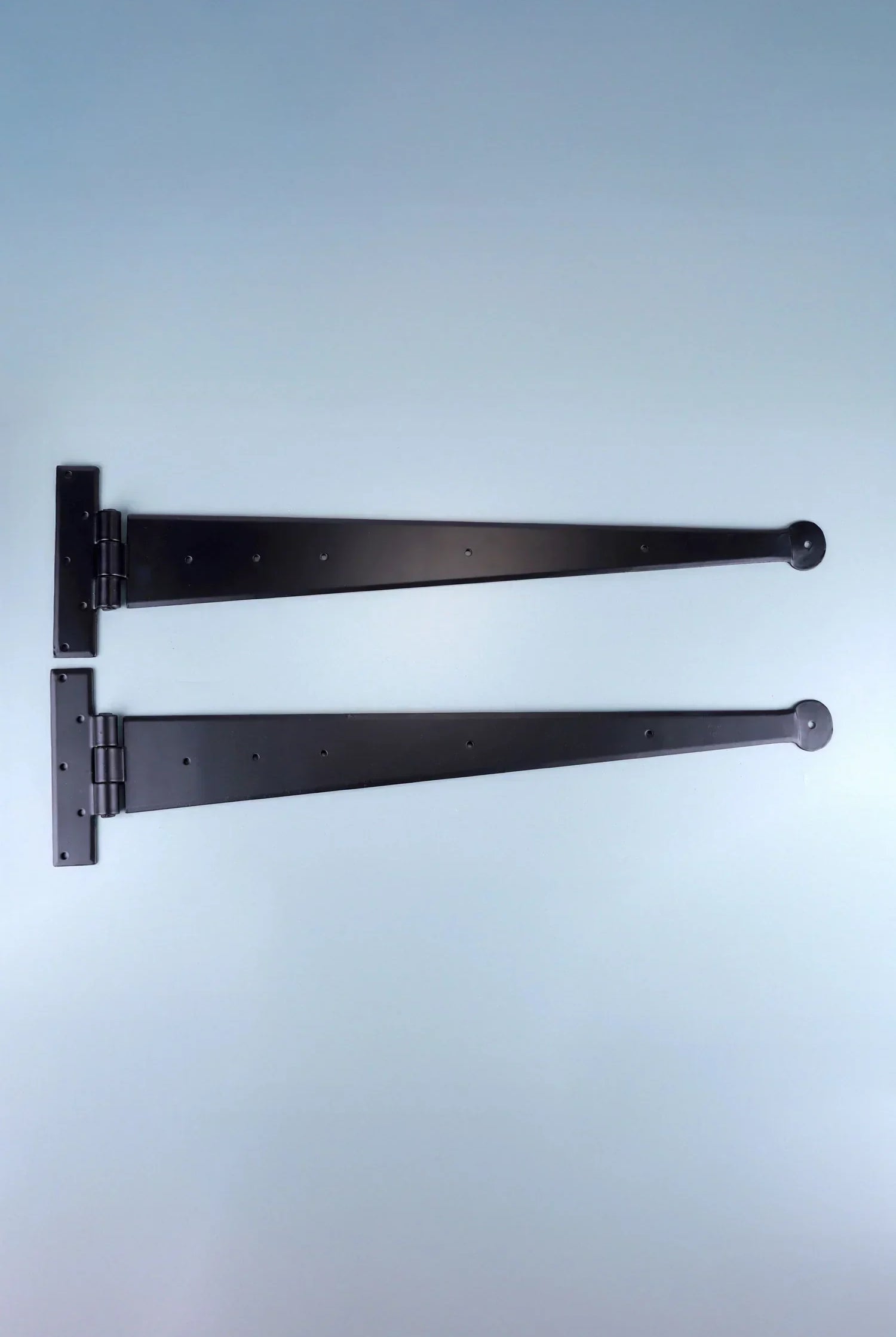 Pair of black metal T-hinges for doors or gates, displayed on a plain light background.