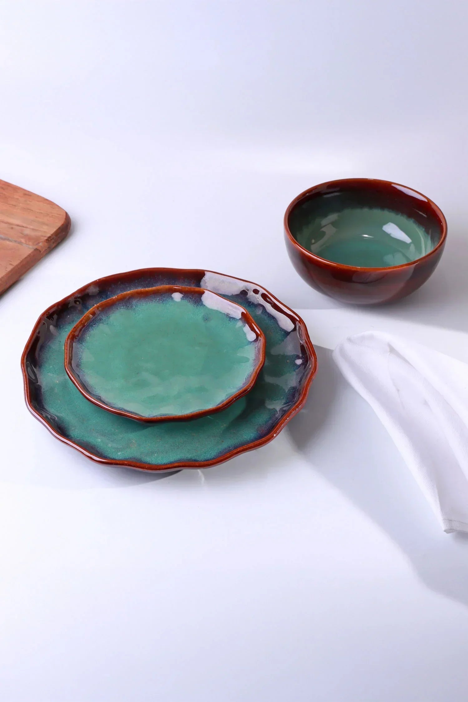 G Decor ceramic tableware set with green and brown plates and bowl on white background