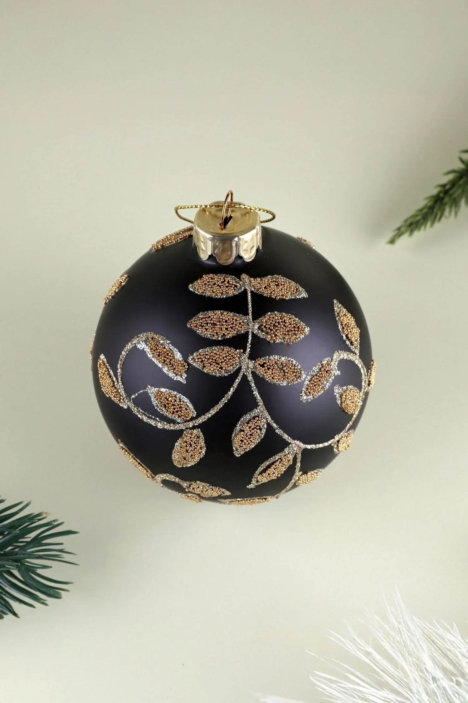 Black and Gold Leaf Hand-Decorated Glass Christmas Bauble — close-up view, G Decor