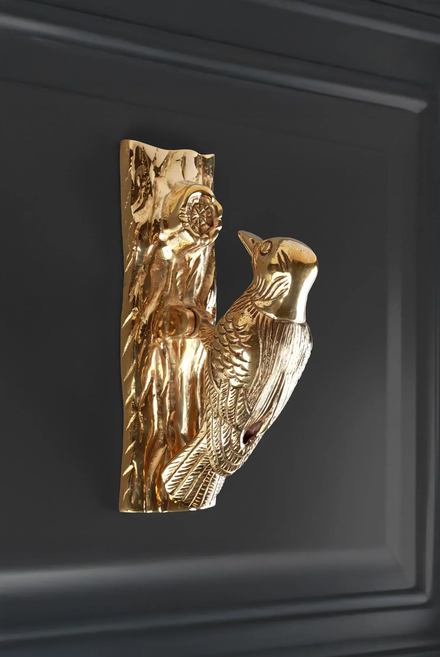 Gold bird-shaped decorative door handle on a dark panel, luxury home hardware by G Decor