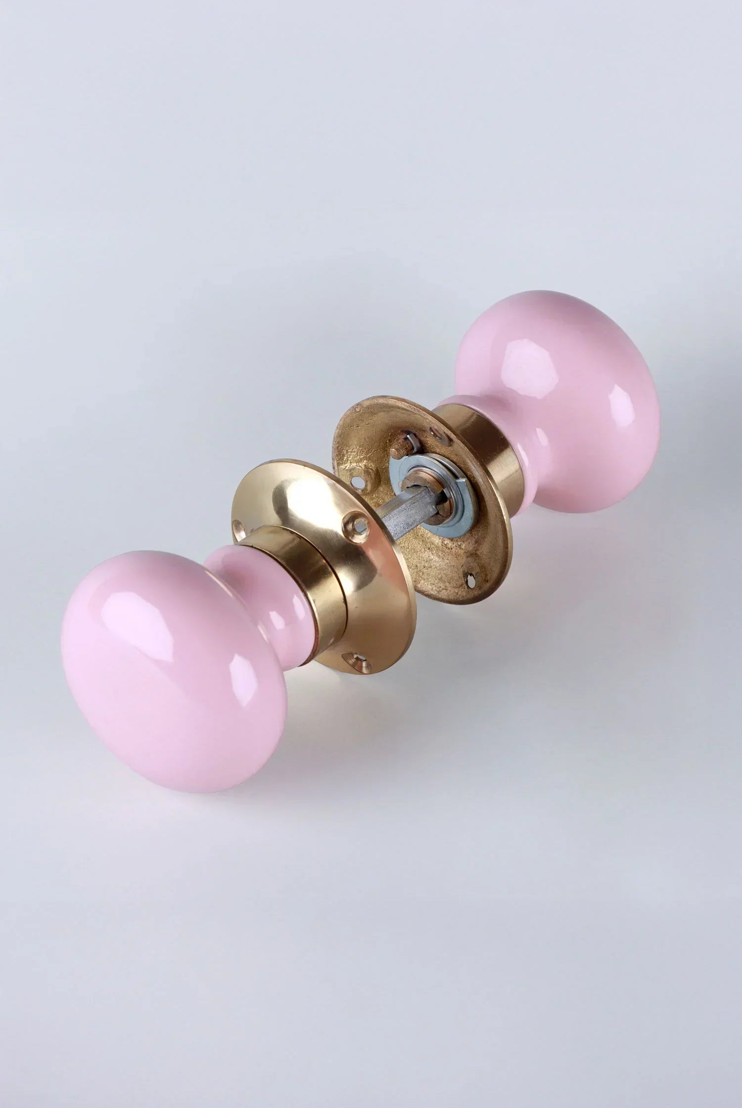 Pink ceramic and gold door knob set on white background, luxury hardware by G Decor