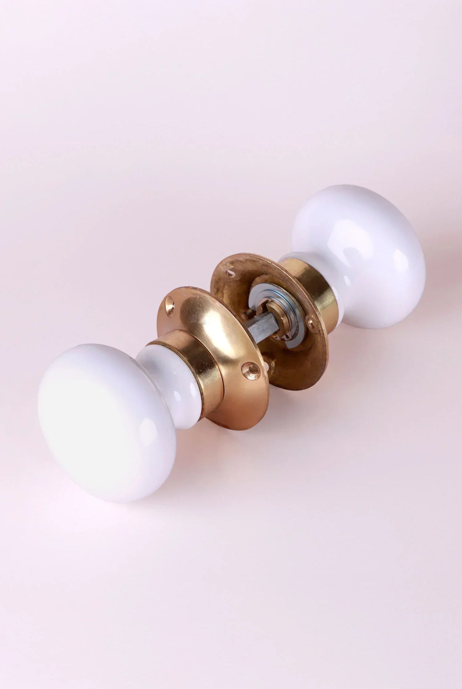 White ceramic and gold door knob set from G Decor on light background