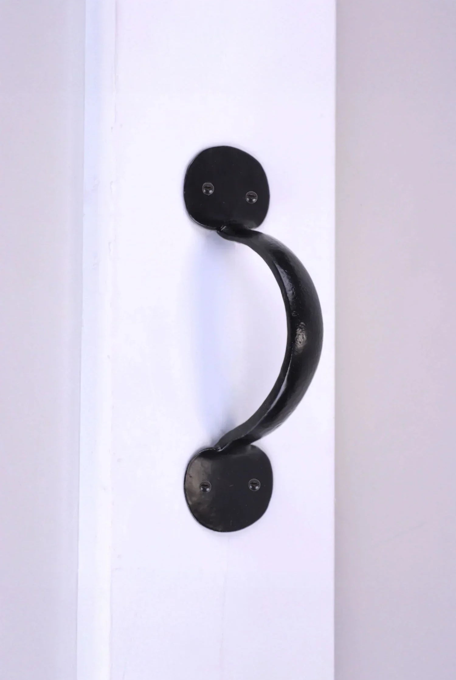 Black metal door handle on white surface, luxury hardware by G Decor
