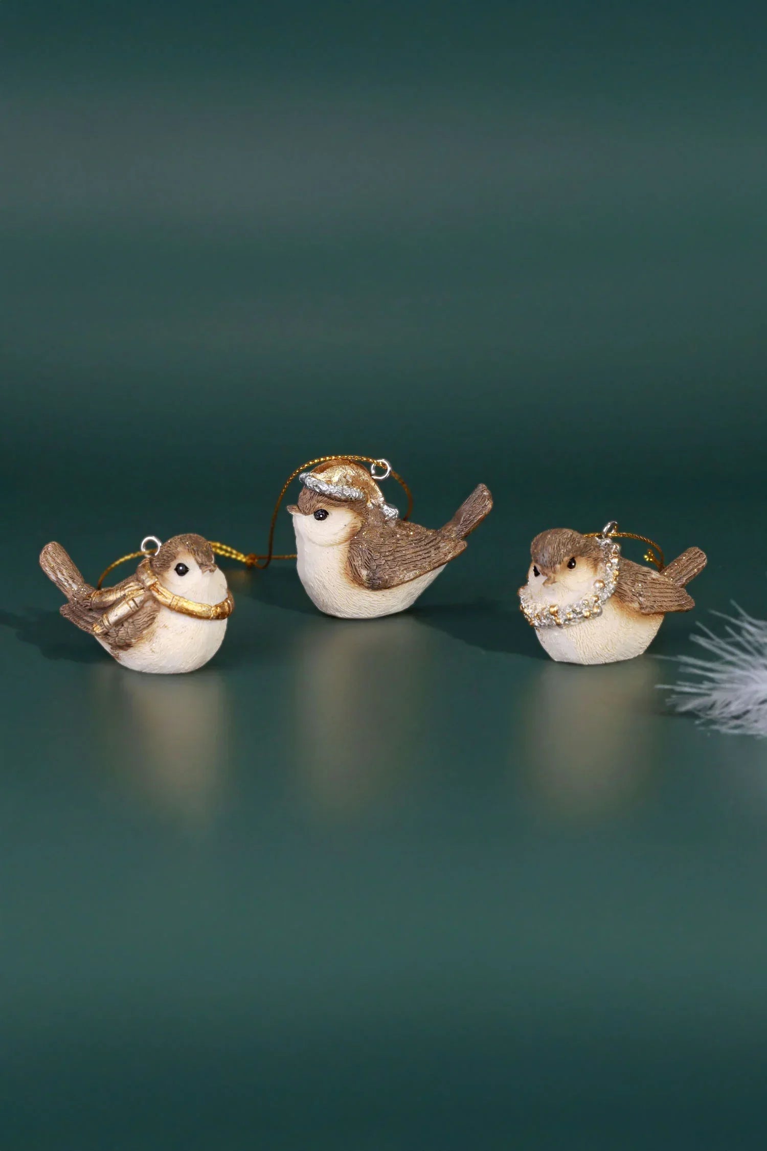 G Decor luxury bird ornaments with gold and faux jewel details on a green background