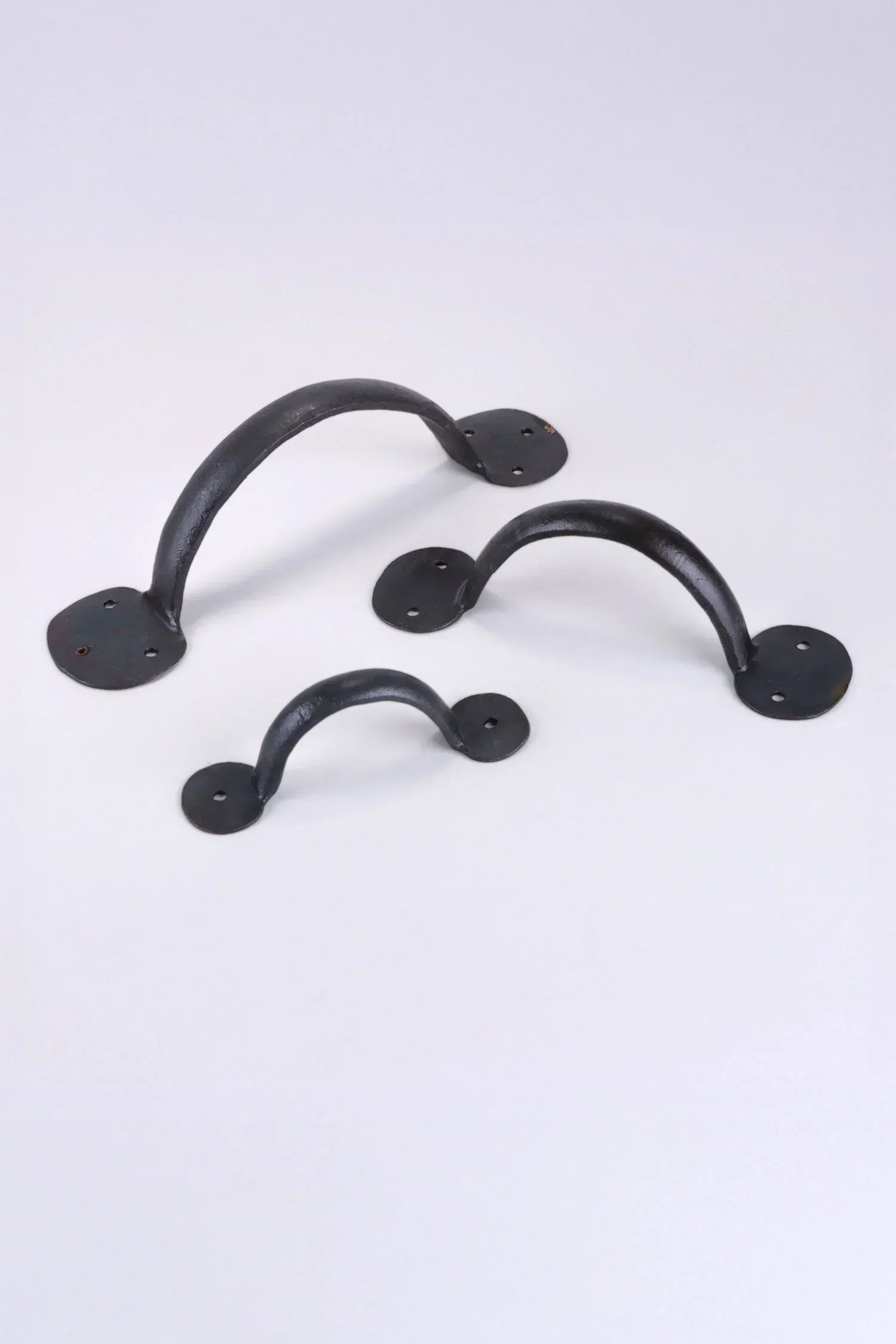 Set of three black metal cabinet handles from G Decor on a white background