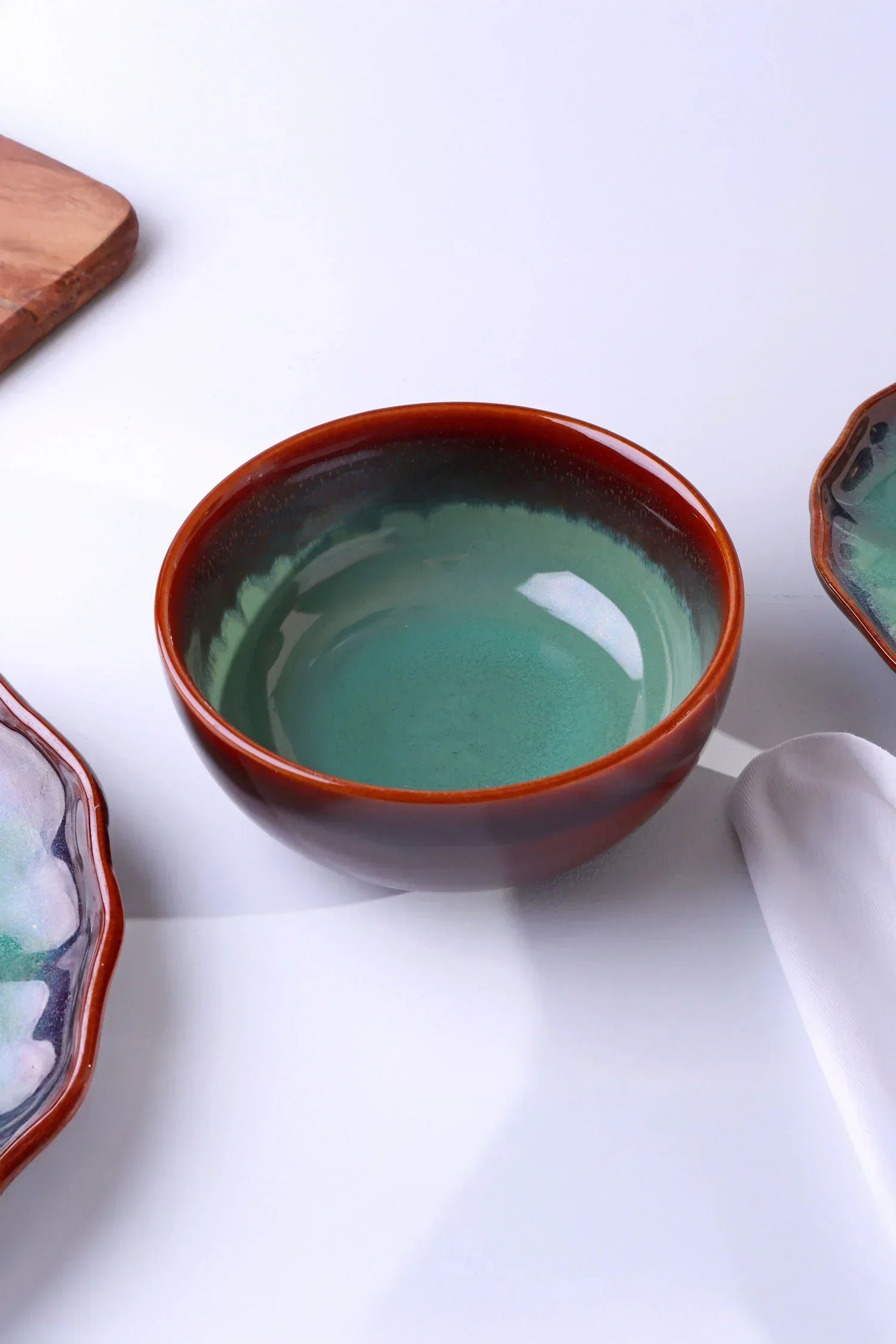 Ceramic bowl with green interior and brown rim on white surface, luxury tableware by G Decor