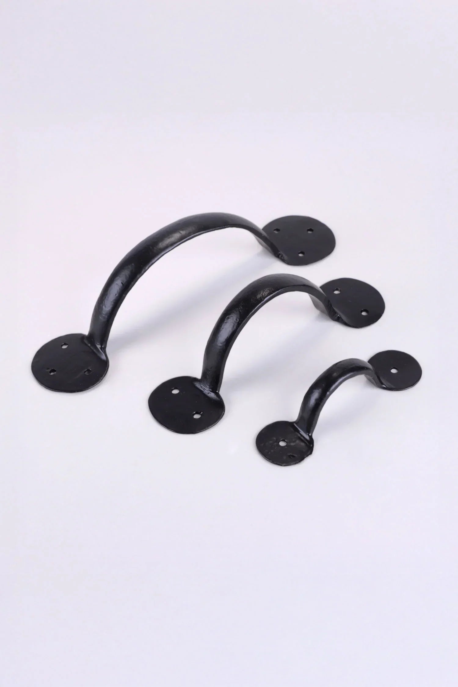 Set of three black metal cabinet handles on white background, luxury G Decor hardware