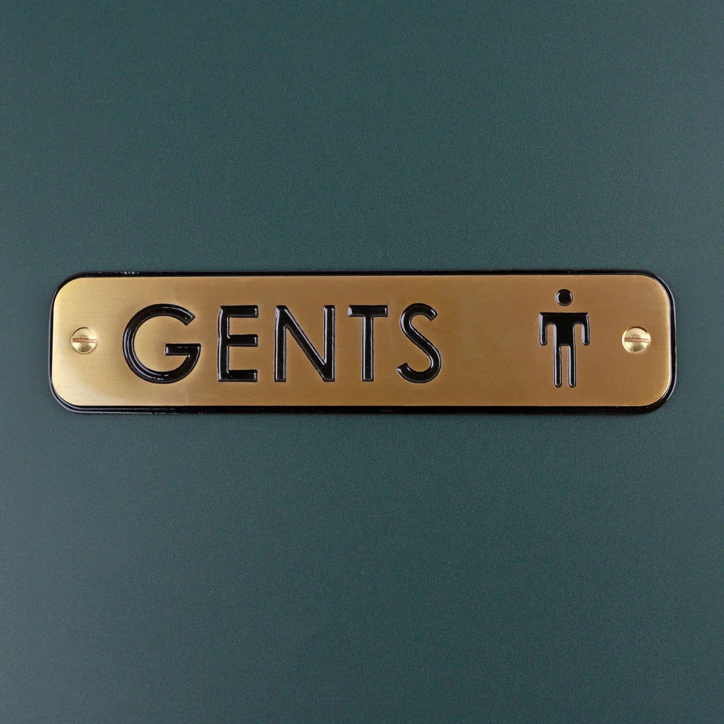 Gold Gents restroom door sign with black engraved text by G Decor on a dark background