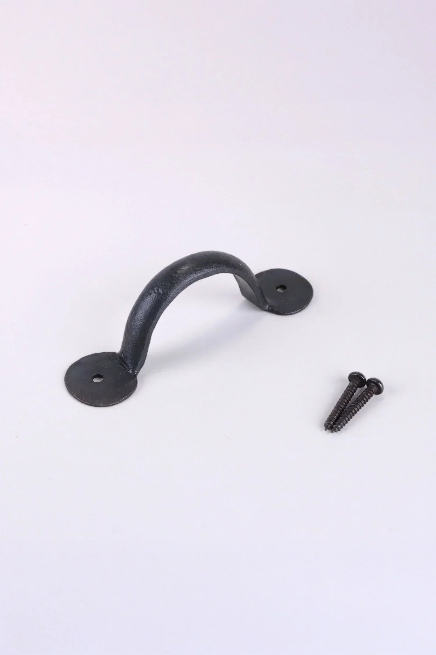 Black metal hardware handle with screws on white background from G Decor collection